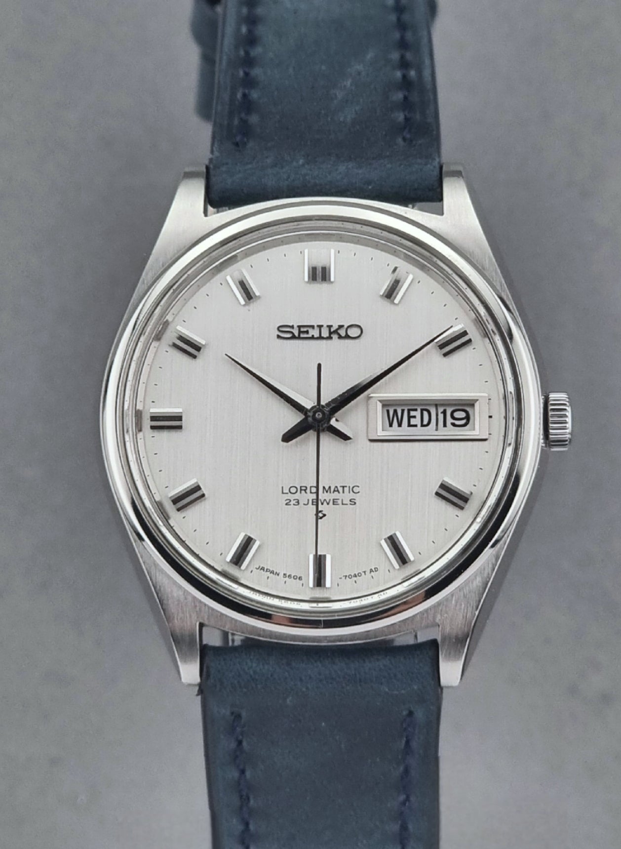 Vintage Seiko watch with blue strap on a gray background