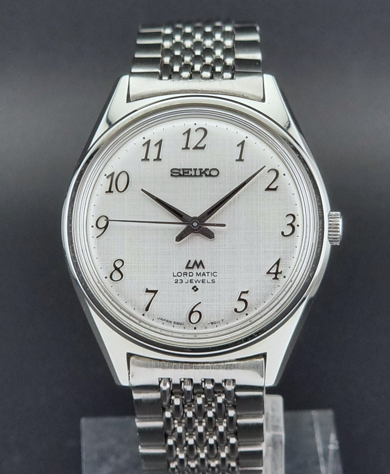 Silver Seiko Lord Matic watch with a white face on a dark background