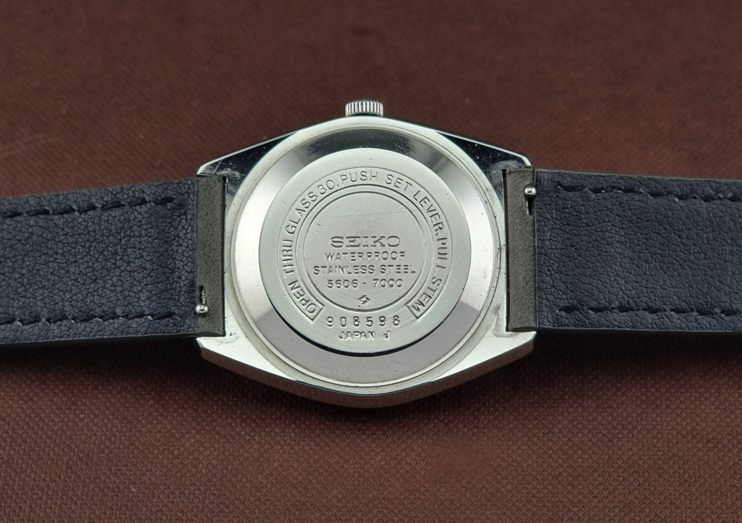 Vintage Seiko Wristwatch LordMatic 5606-7000 back view on a brown background