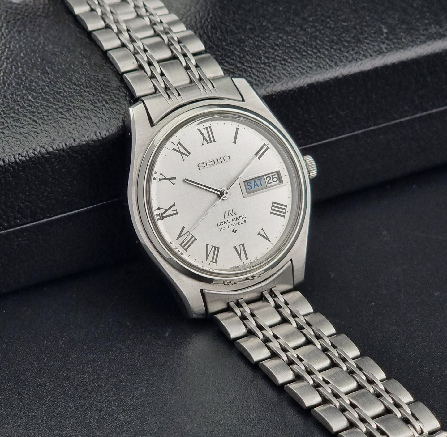 Vintage Seiko Wristwatch LordMatic 5606-7030 with Roman numeral markers on a dark background
