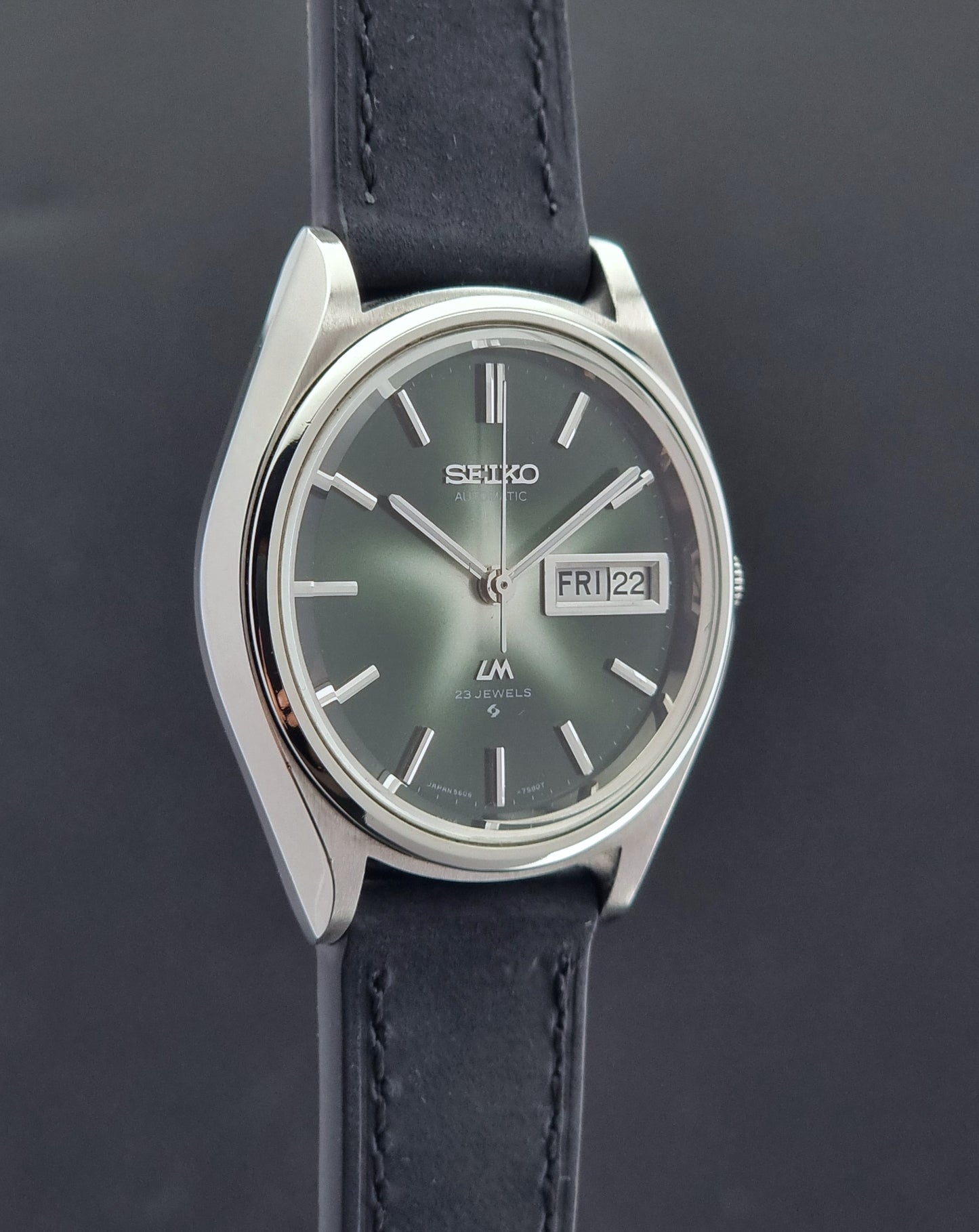 Side view of a Seiko Lord Matic watch with black leather strap on a dark background