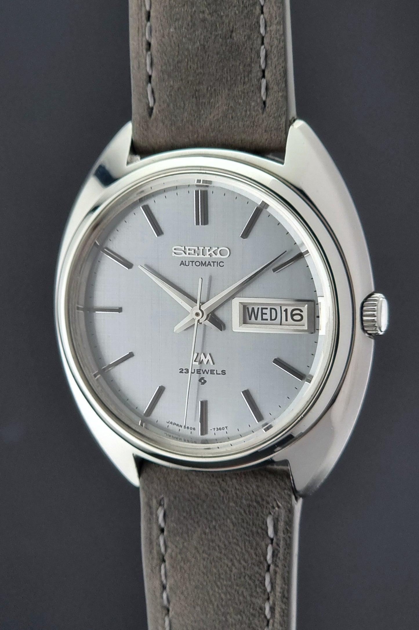 Seiko watch with gray leather strap on a dark background