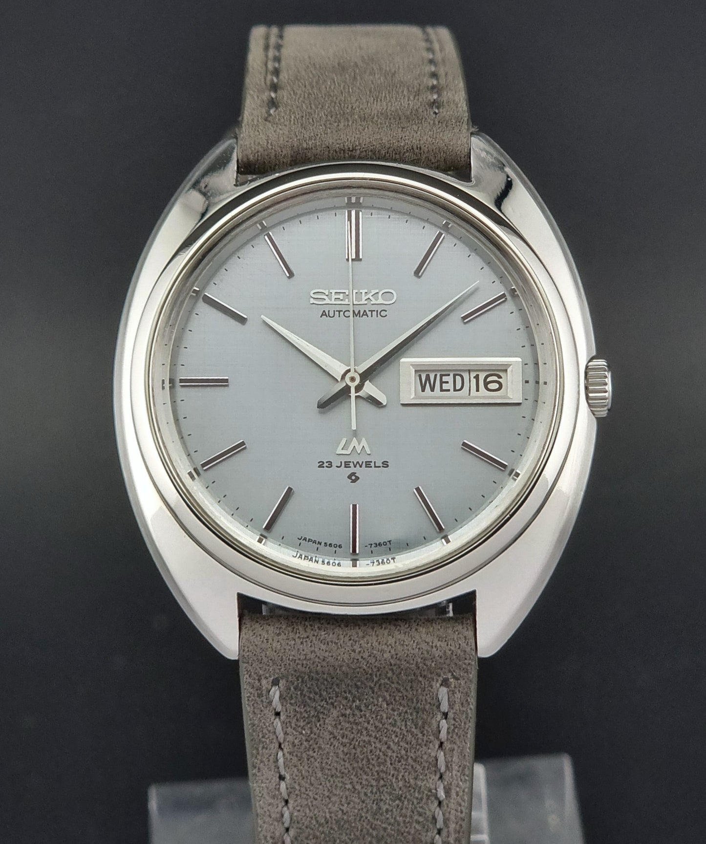 Seiko watch with gray strap and silver case on a dark background