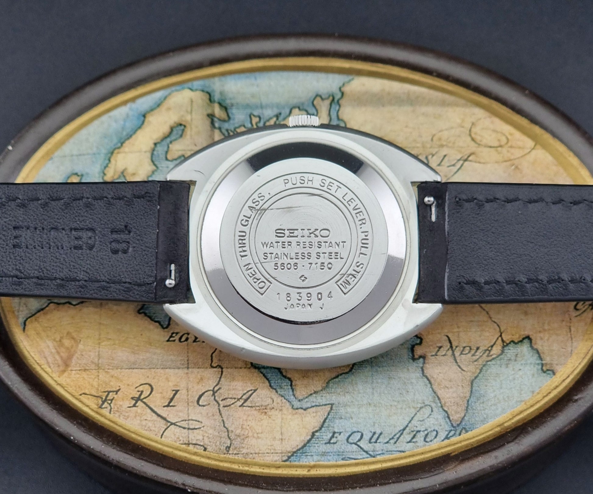 Vintage Seiko Lord Matic 5606-7150 watch with black leather strap on a dark background case back