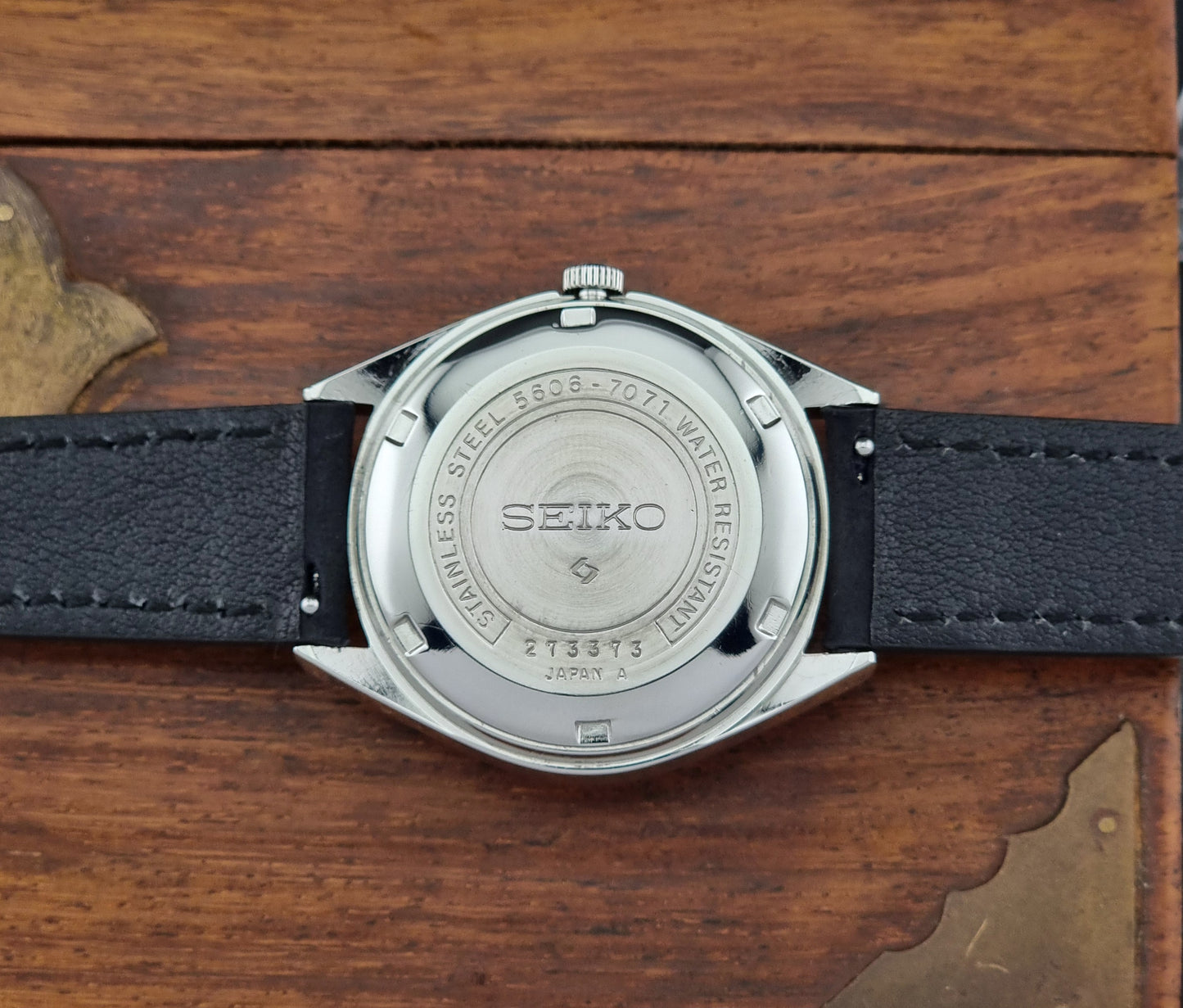 Seiko watch back view on a wooden surface