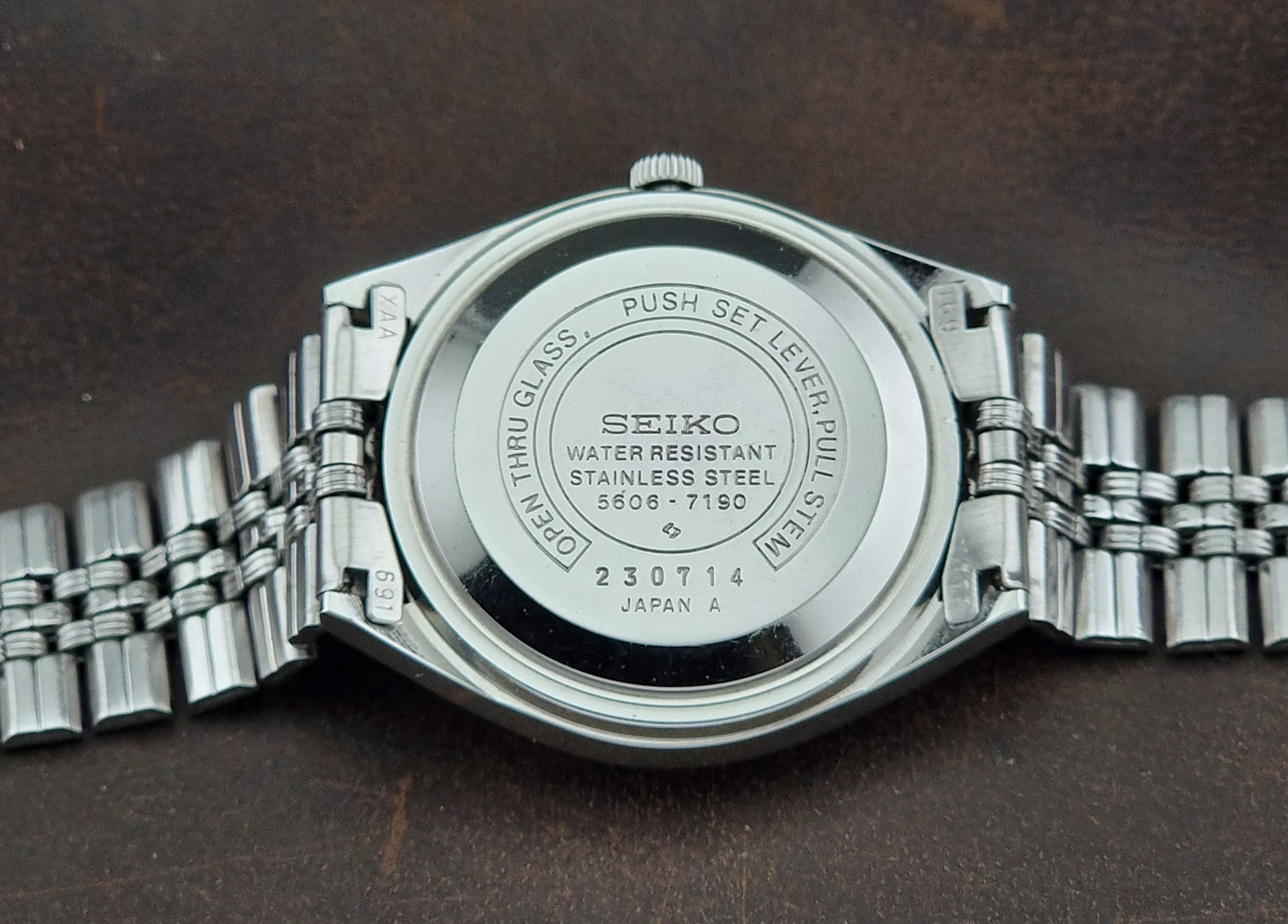 Seiko watch caseback on a dark brown background