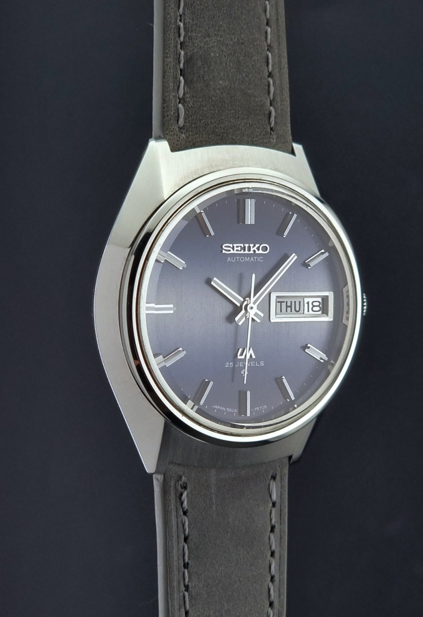 Vintage Seiko 5606-7240 watch with gray leather strap on a dark background
