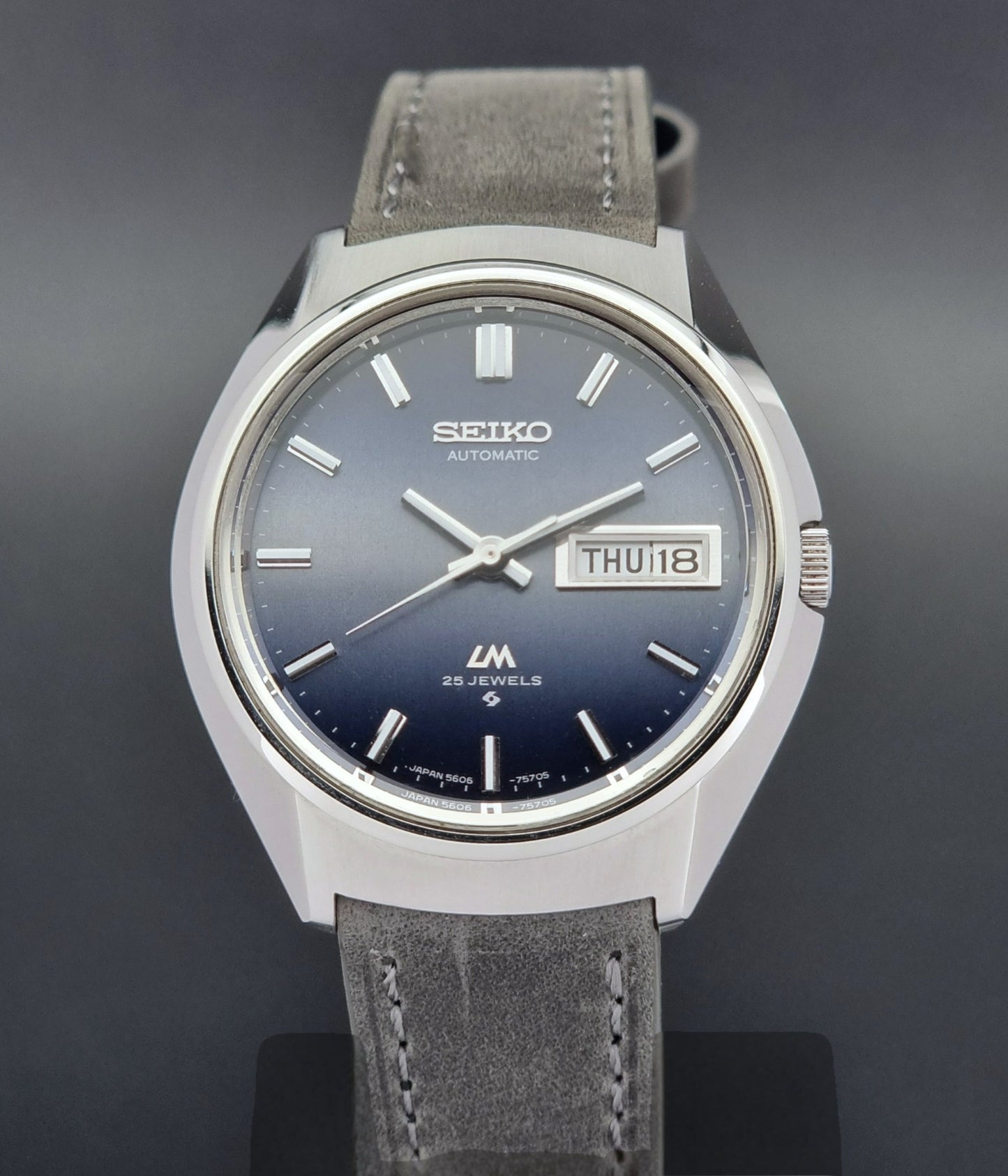 Vintage Seiko 5606-7240 watch with gray strap on a dark background