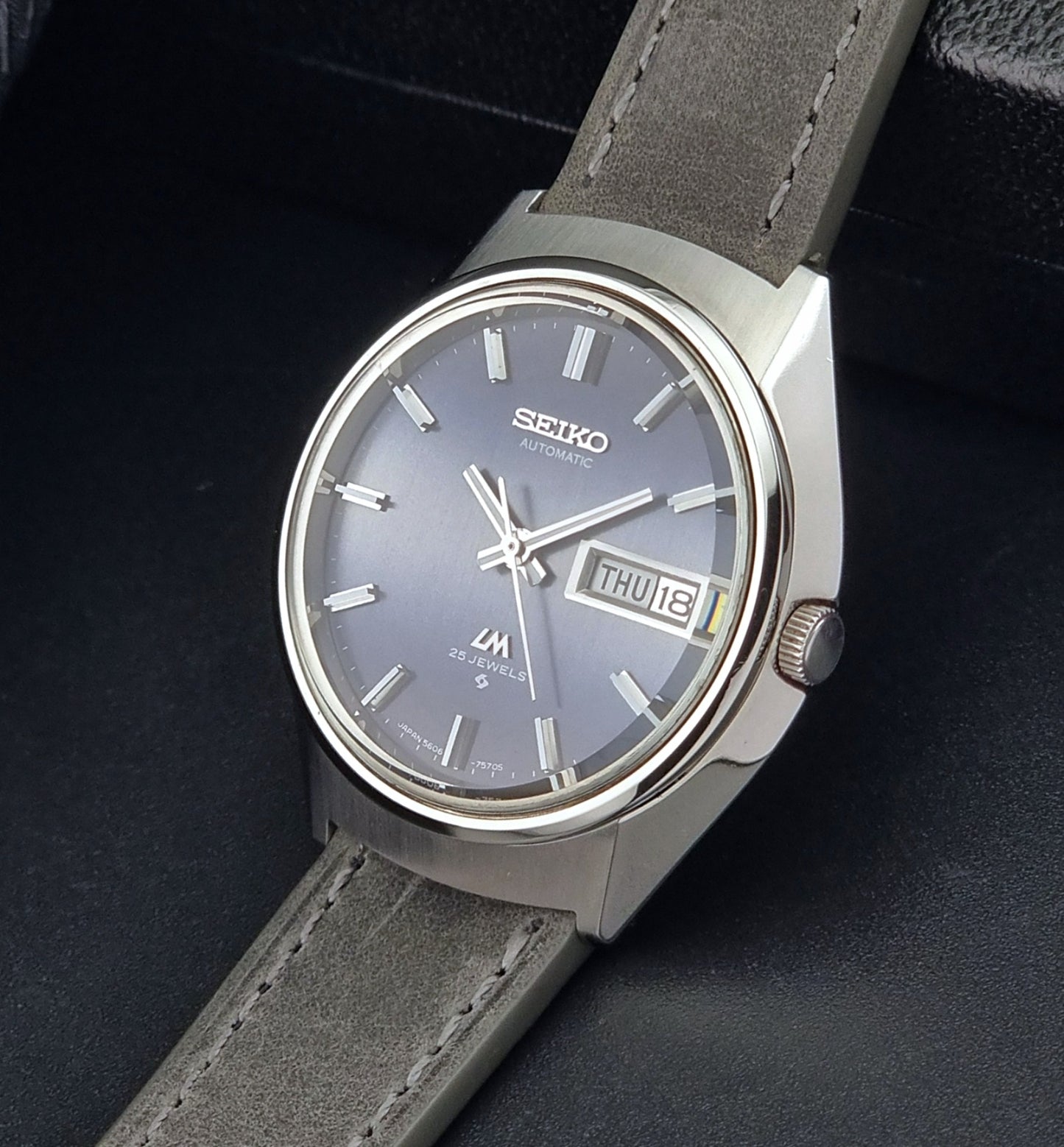 Vintage Seiko 5606-7240 watch with gray strap and blue dial on a dark background
