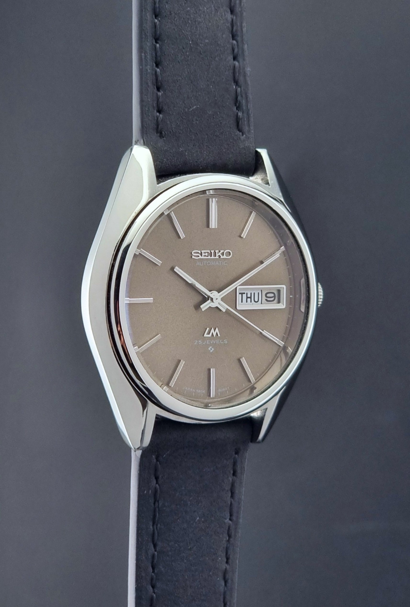 Vintage Seiko Lordmatic 5606-8031 watch with a brown dial and a dark strap side profile