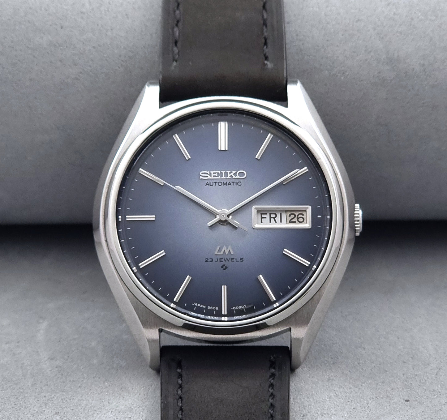 Vintage Seiko Wristwatch LordMatic 5606-8050 with blue gradient dial on a dark surface close up dial view