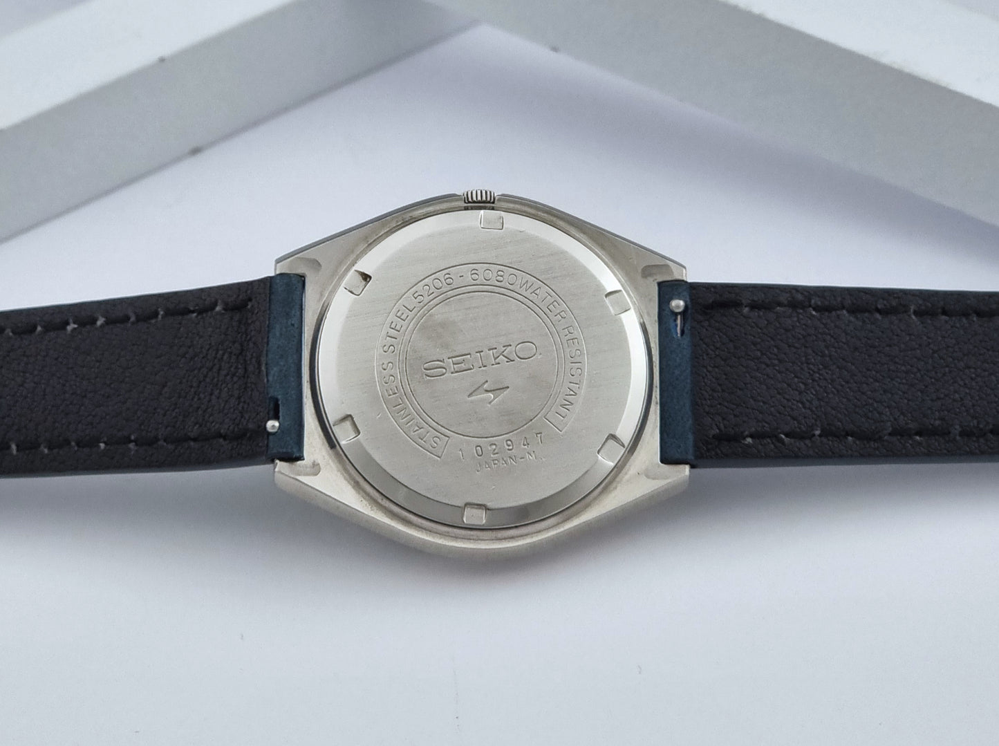 Vintage Seiko watch LordMatic Special 5206-6080 with blue strap and dark blue dial on a surface case back view