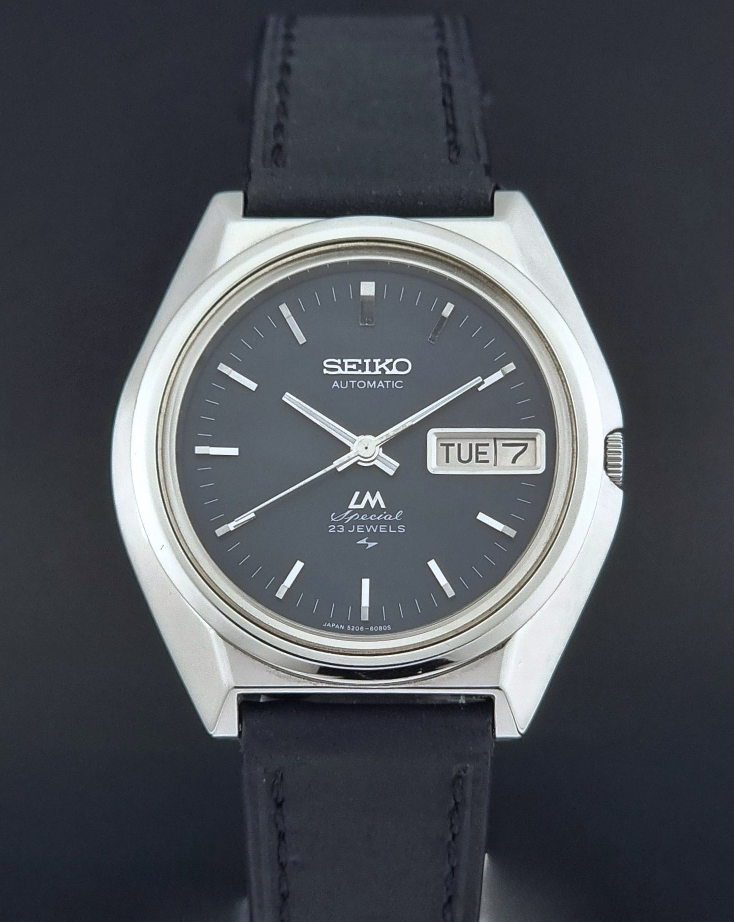 Vintage Seiko Lord Matic Special 5206-6080 watch with black leather strap on a gray background close up