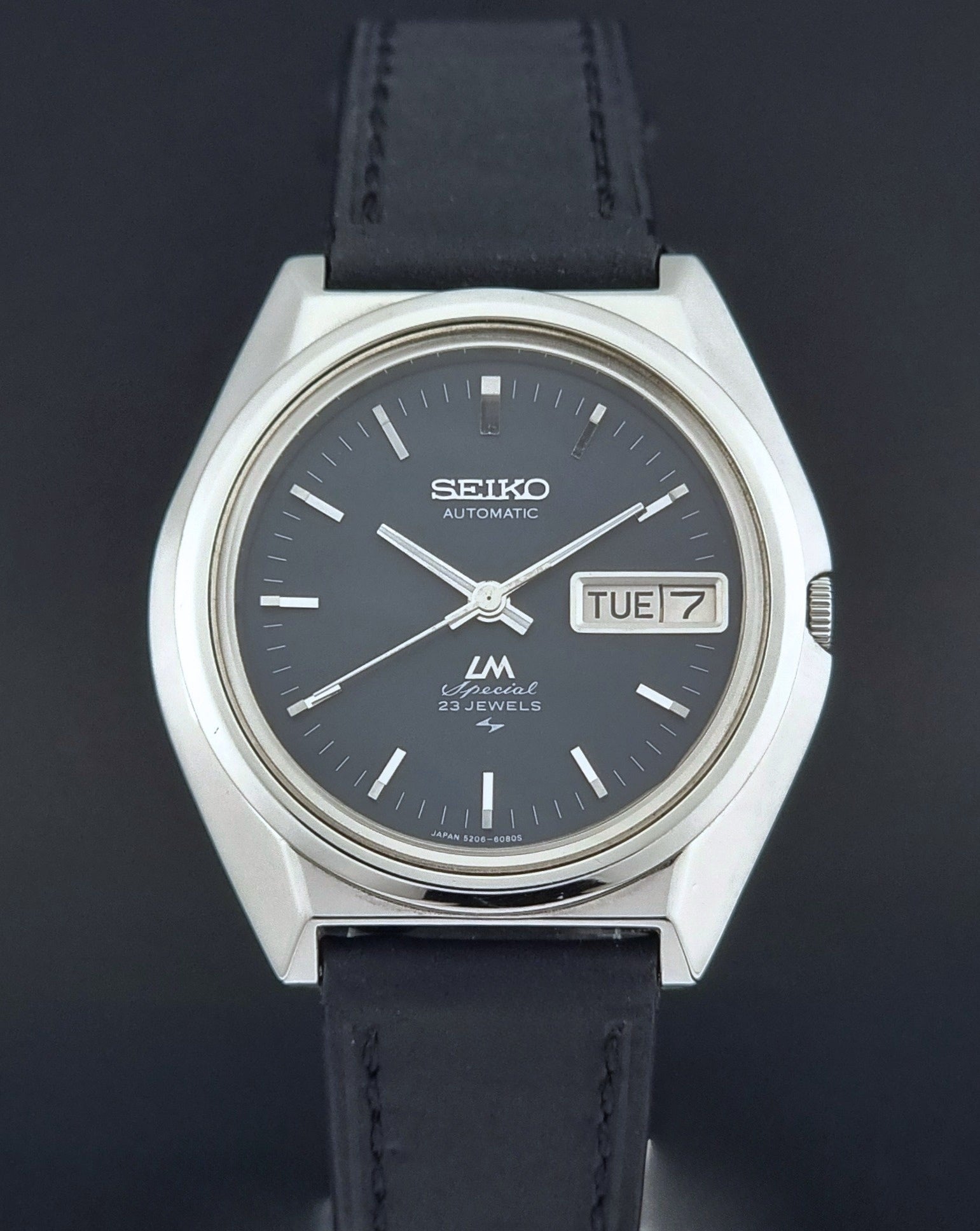 Vintage Seiko Lord Matic Special 5206-6080 watch with black leather strap on a gray background close up
