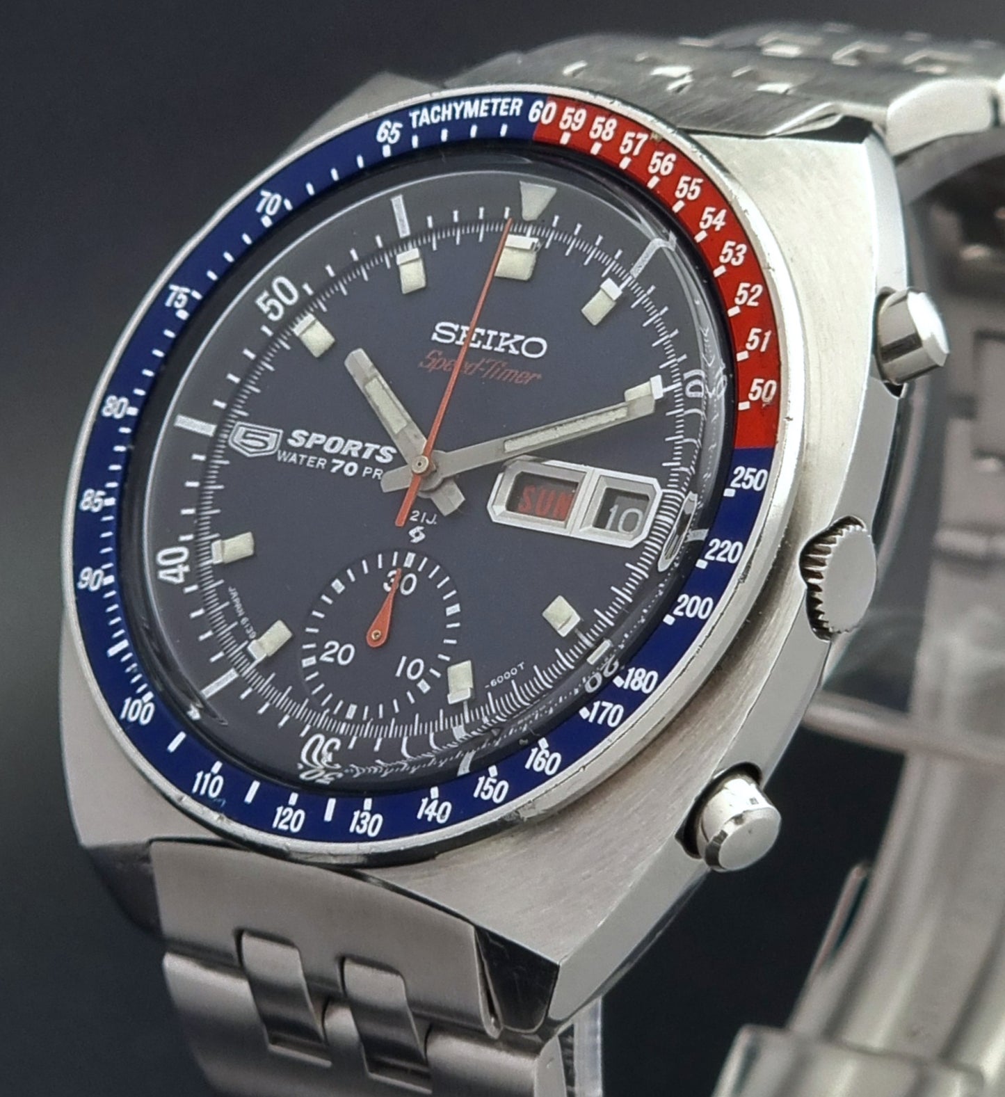 Seiko watch with blue and red accents on a dark background