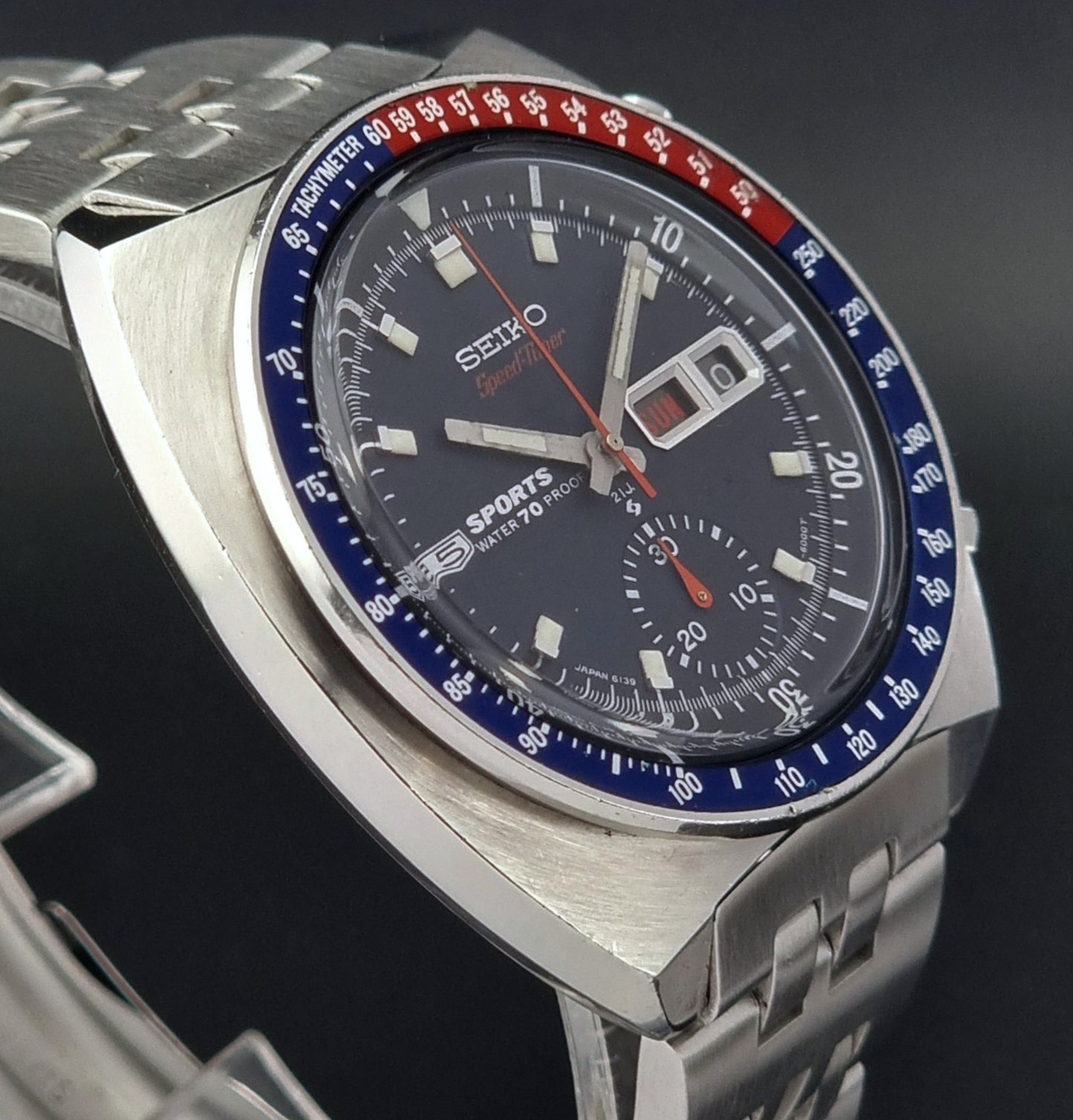 Seiko speedtimer watch with blue and red bezel on a dark background