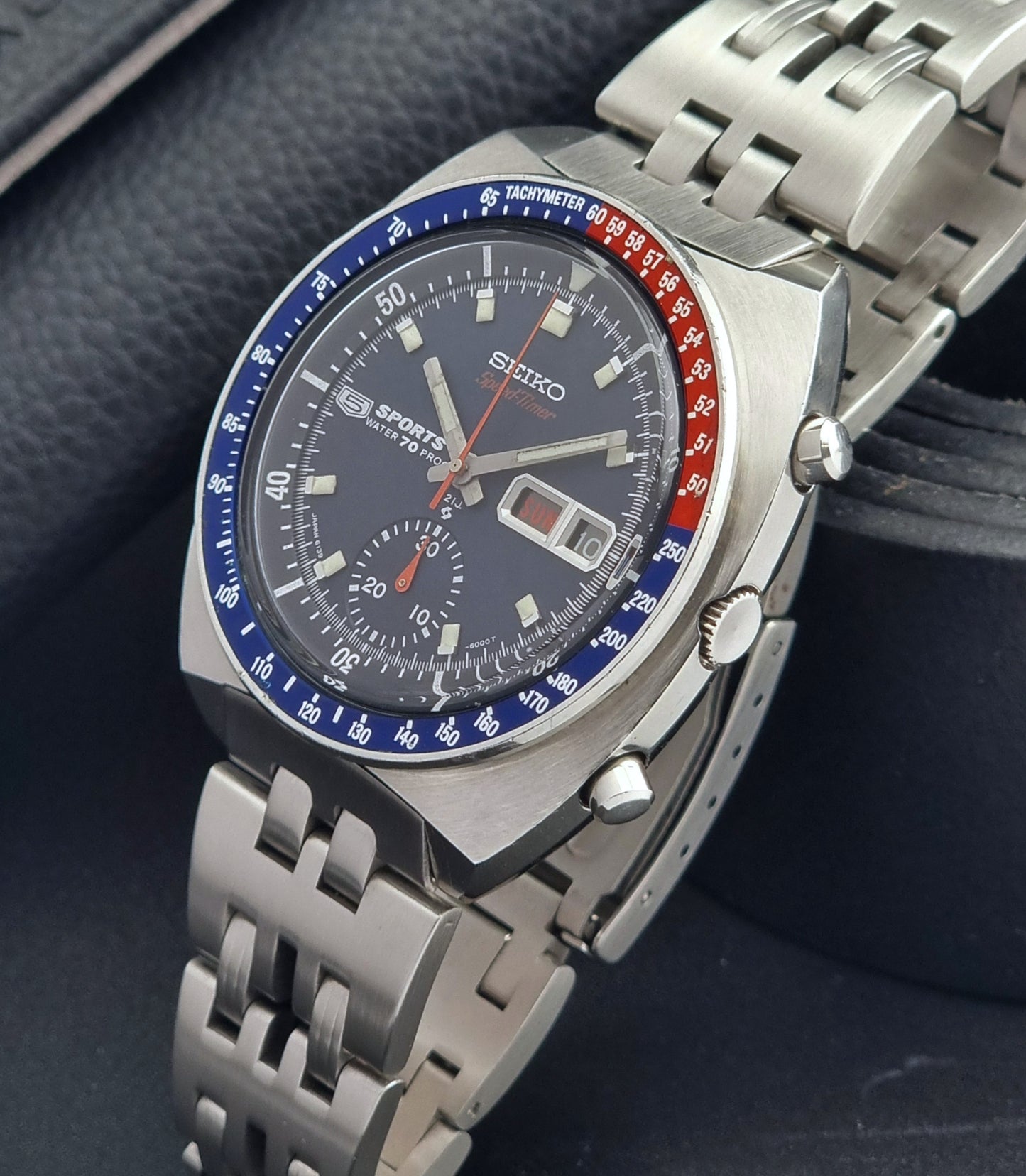 Seiko watch with a silver metal strap on a dark background