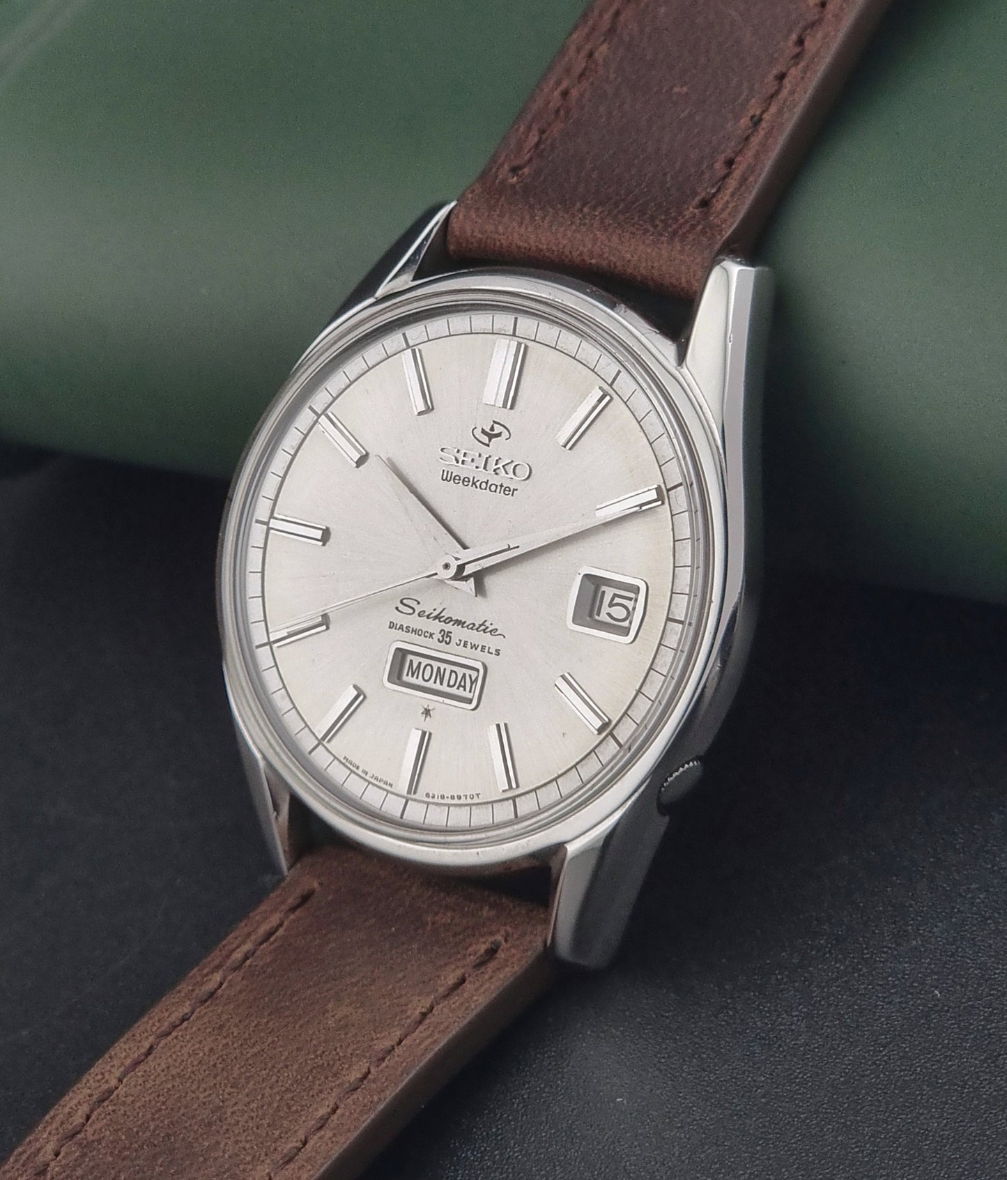 Vintage Seiko watch with brown leather strap on a dark surface