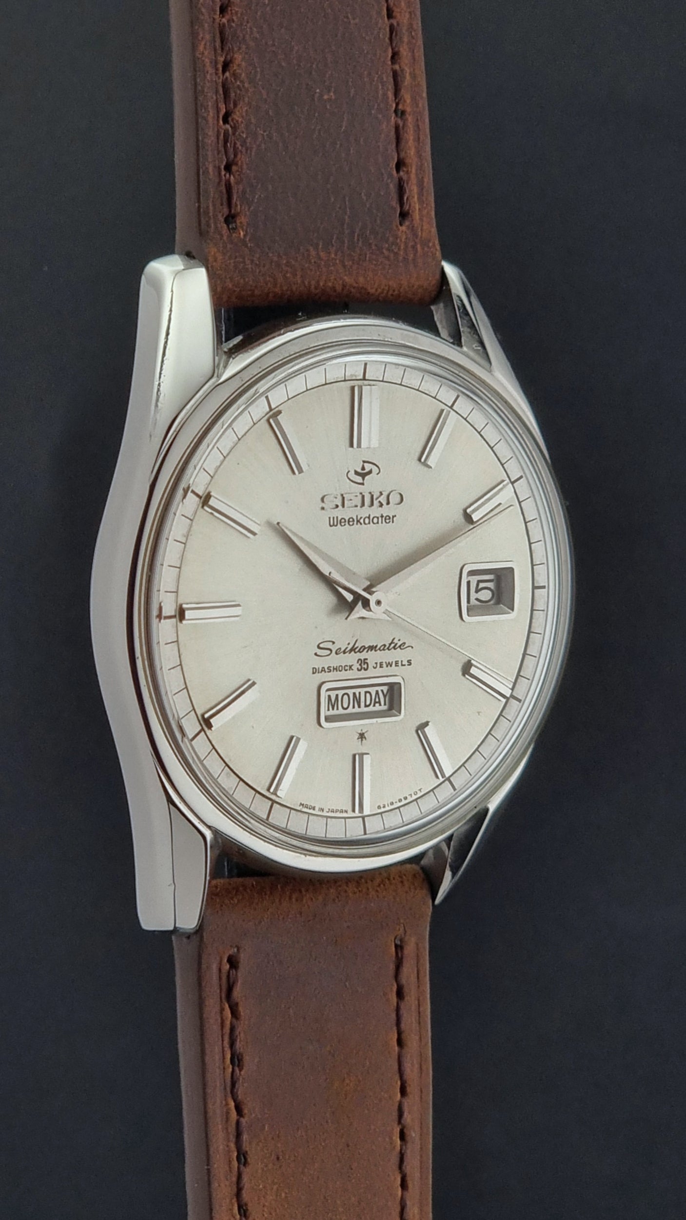 Vintage Seiko watch with brown leather strap and silver case on a dark background