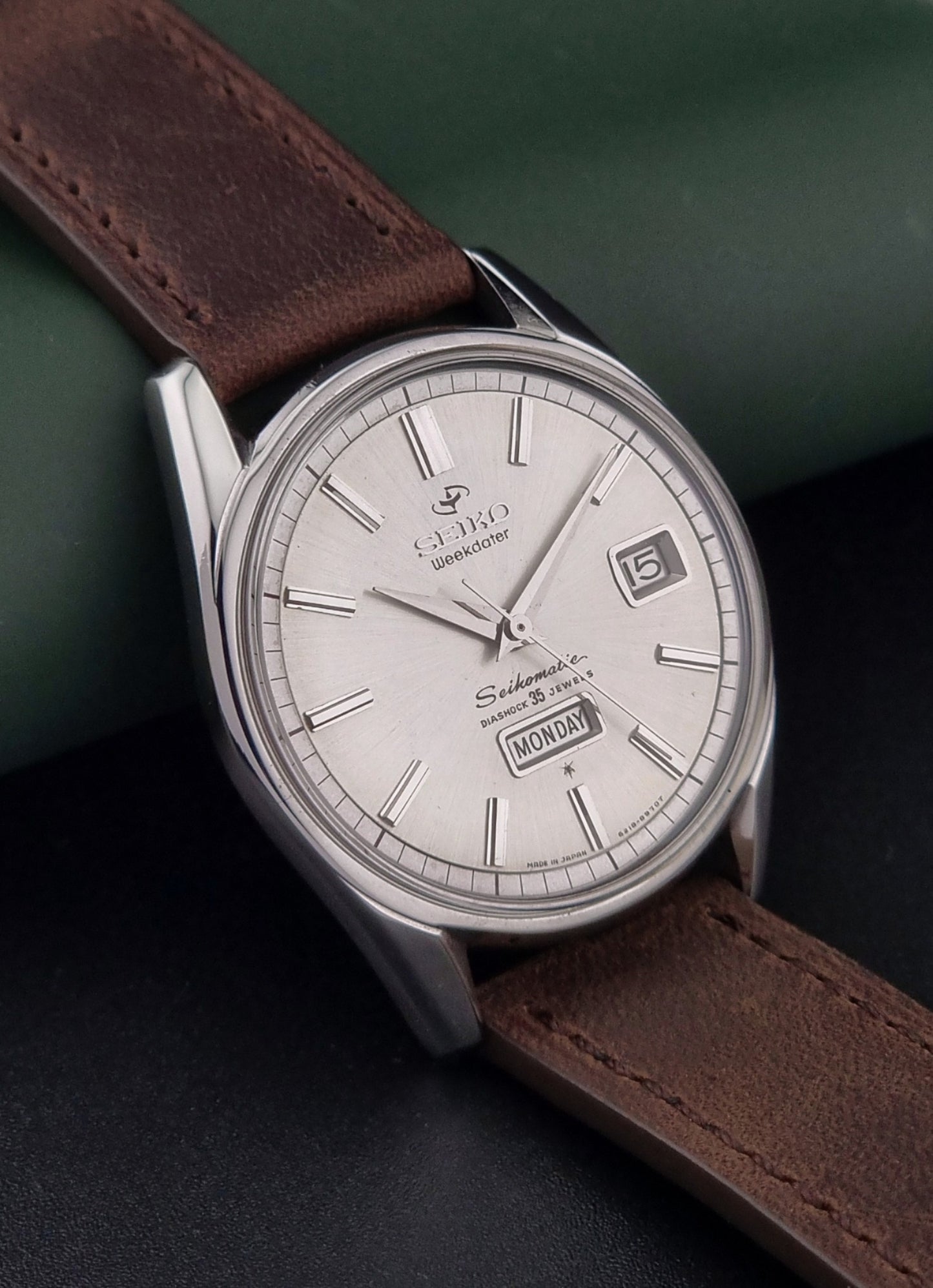 Vintage Seiko watch with brown leather strap and silver dial on a dark surface