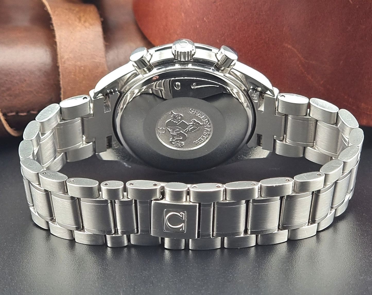 Vintage Omega speedmaster watch with a detailed face on a dark surface