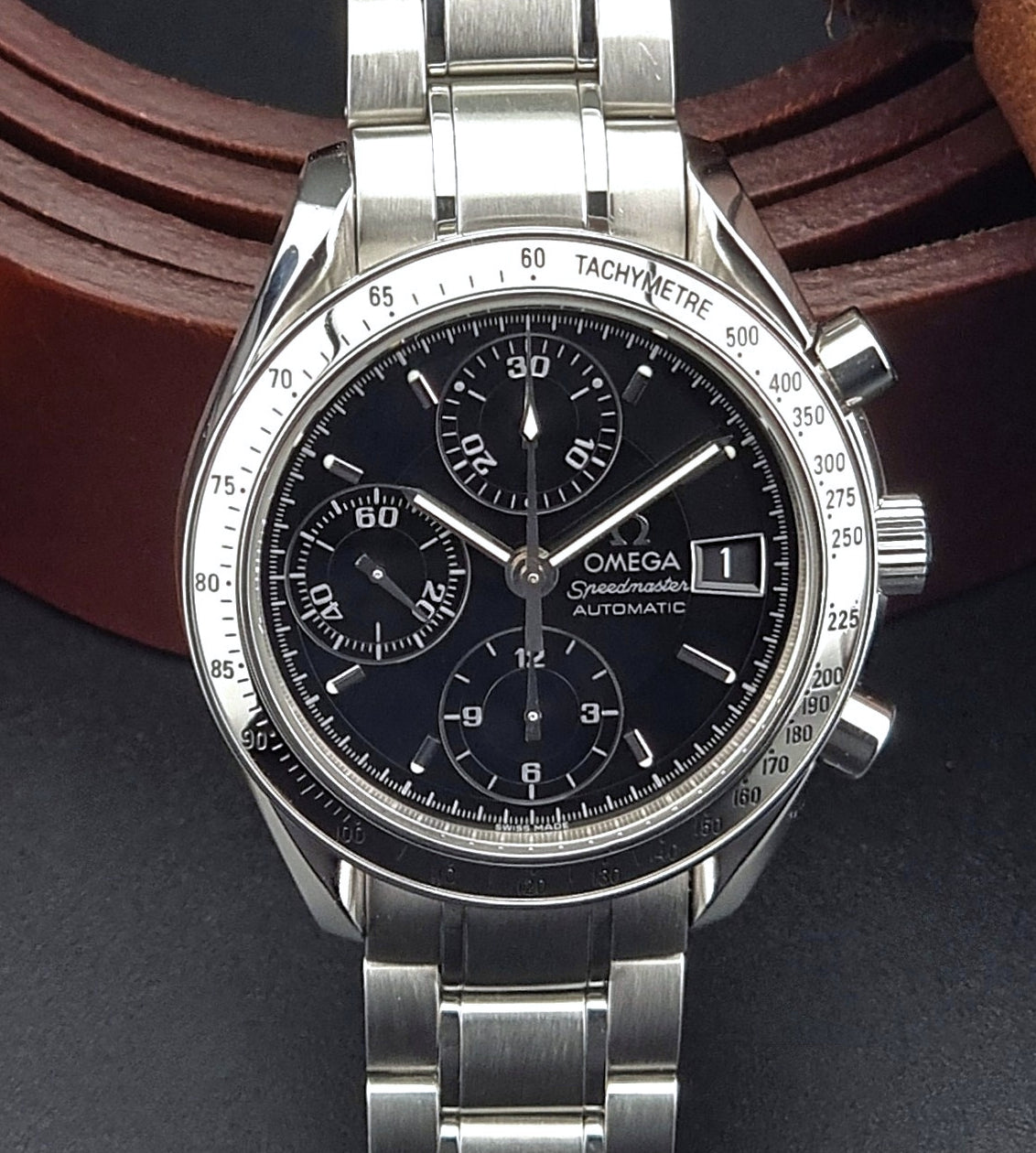 Omega Speedmaster 3513.50 watch with black dial on a dark background