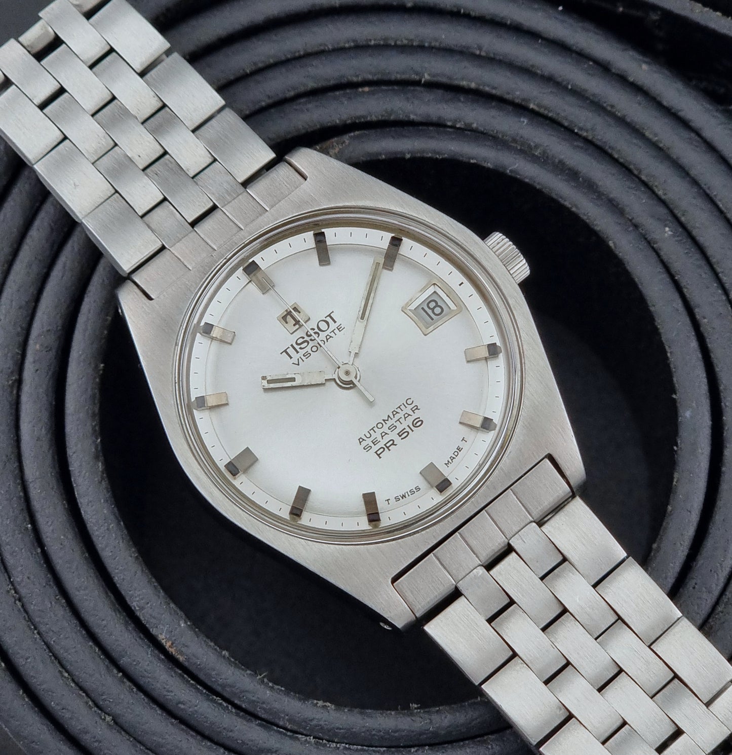 Tissot Seastar Visodate watch with a white dial on a textured black background
