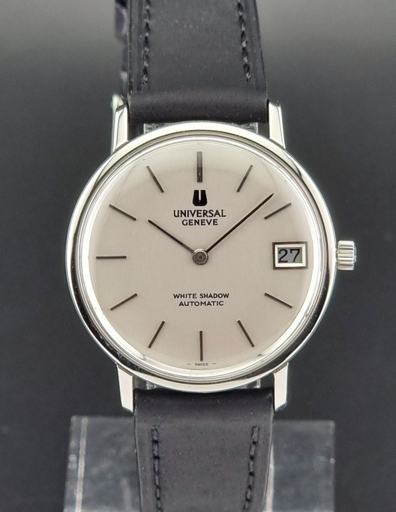Universal Geneve watch with black leather strap on a dark background
