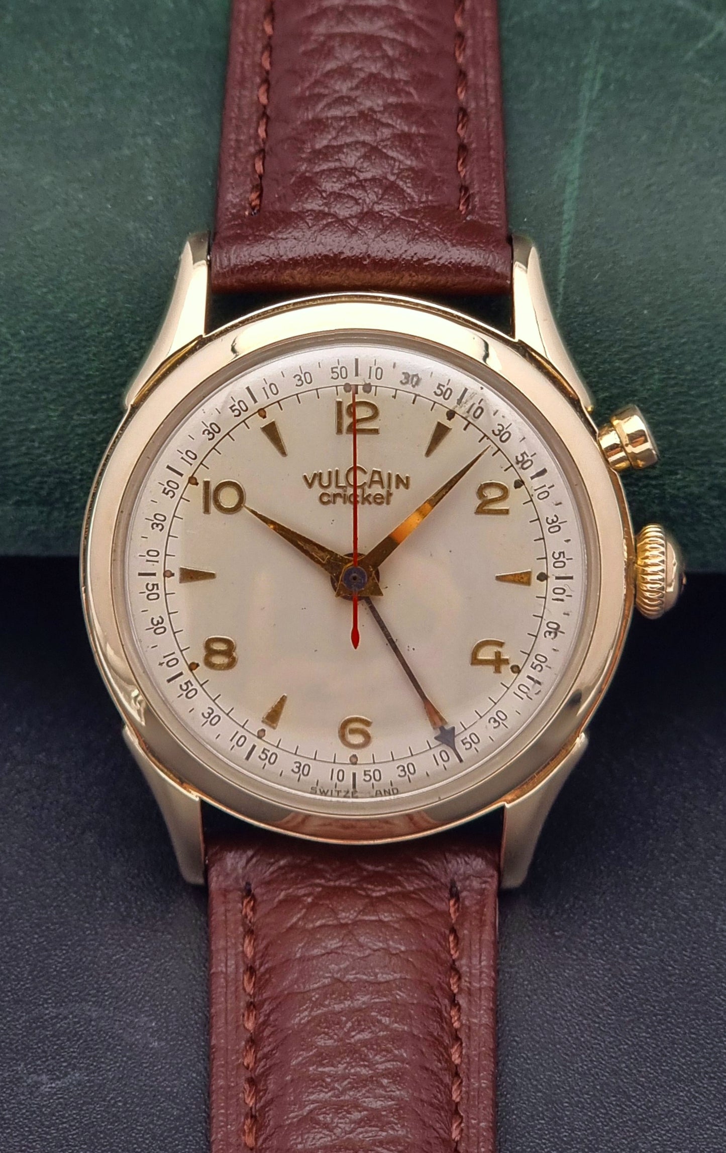 Vintage Vulcain cricket W197446 watch with brown leather strap and gold casing on a dark background