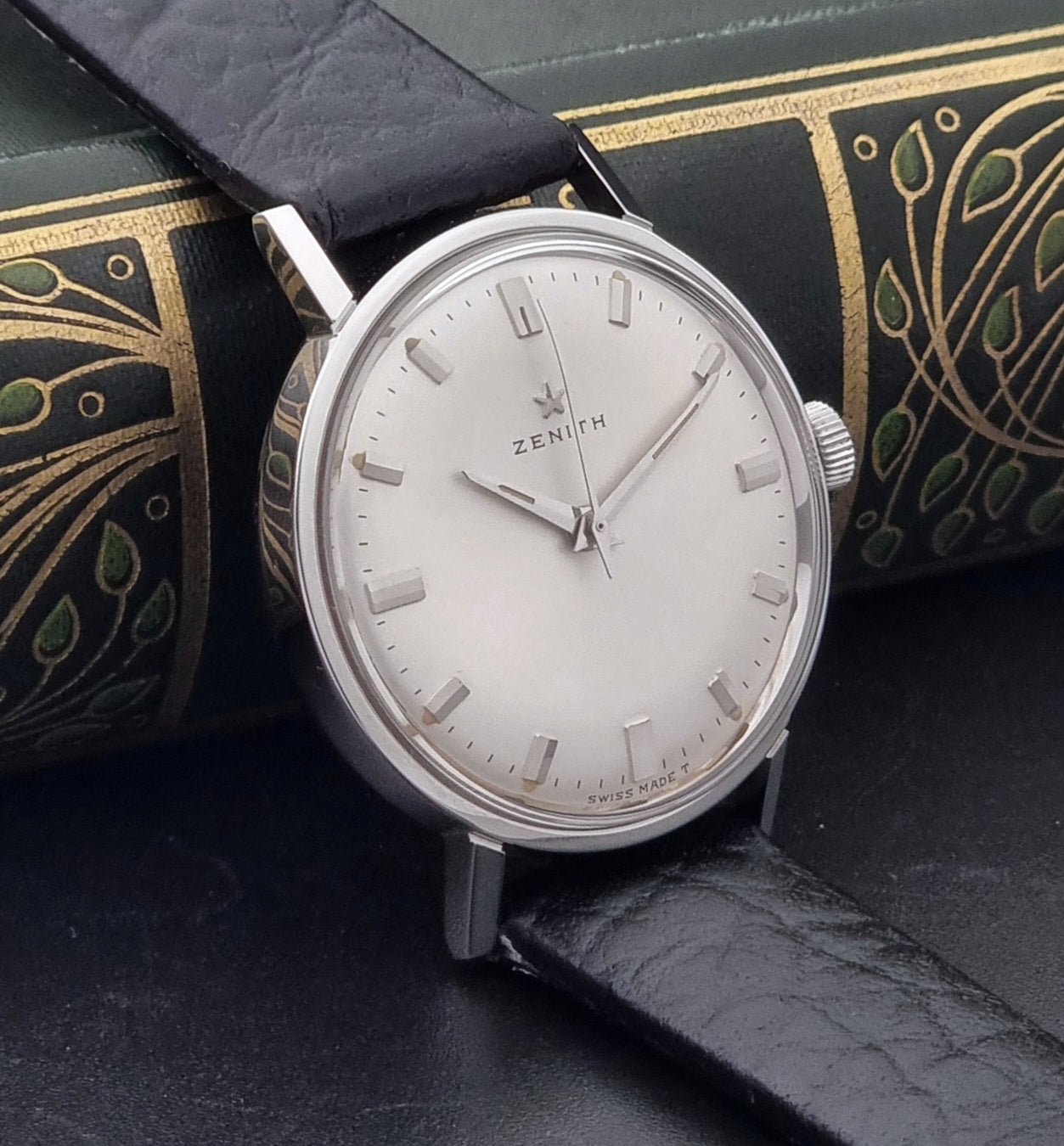 Vintage Unisex Zenith Wristwatch Manual wind with a black strap on a dark background side view