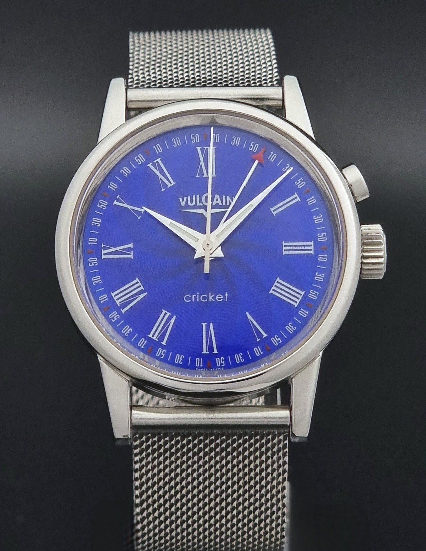Vulcain Cricket Alarm watch 100102.008 with a blue face on a dark gray background front dial view
