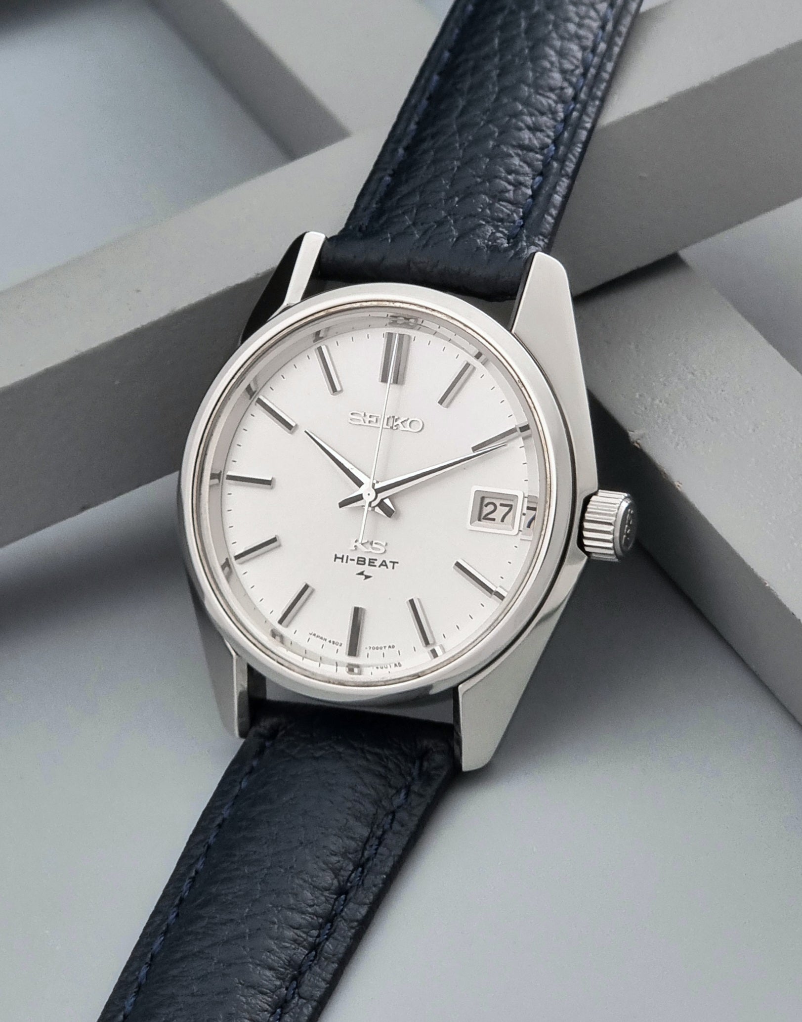 Vintage King Seiko 4502-7001 watch with a blue leather strap on a grey back ground crown view