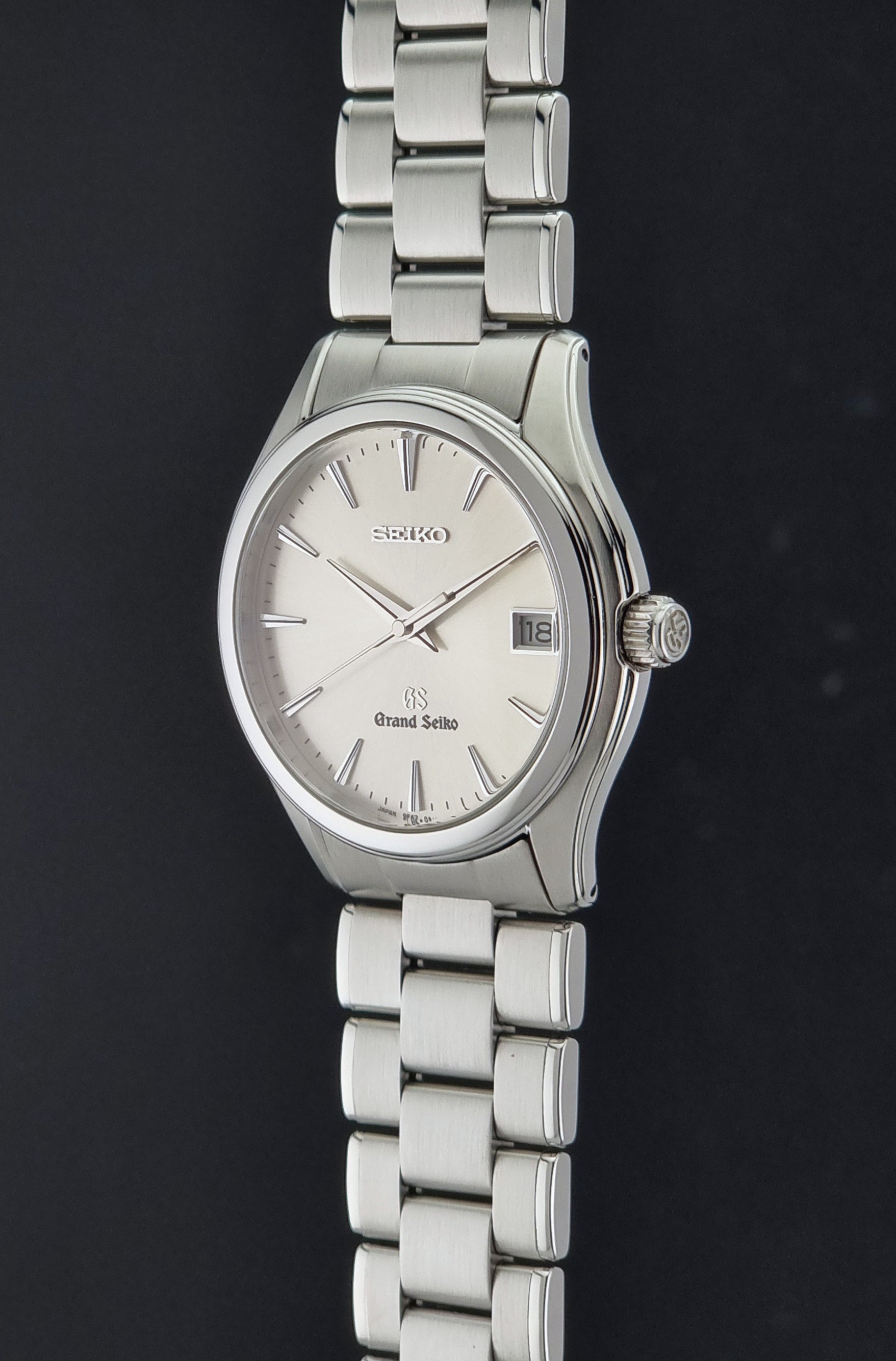 A Grand Seiko SBGX005 quartz watch 9F62-0A10 Sunburst Dial  with bracelet on a dark back ground a crown side profile view