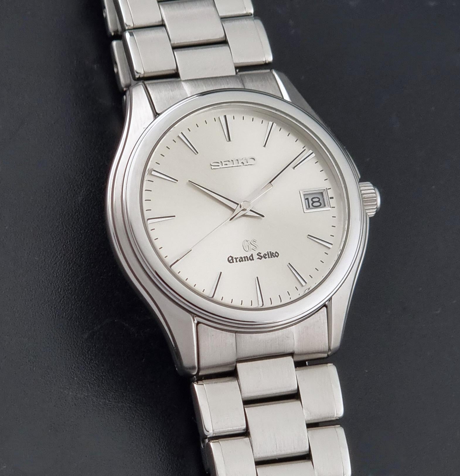 A Grand Seiko SBGX005 quartz watch 9F62-0A10 Sunburst Dial  with bracelet on a dark back ground a close up of the dial