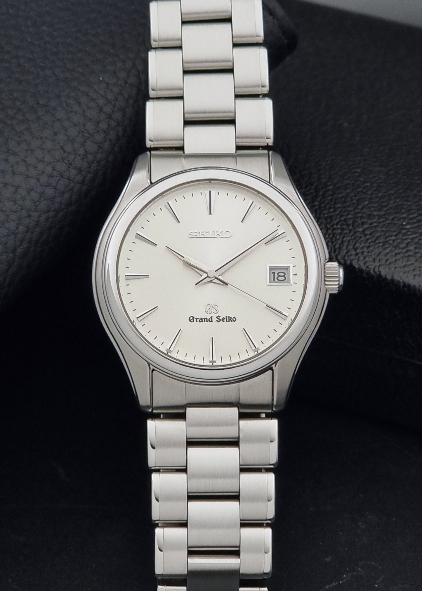 A Grand Seiko SBGX005 quartz watch 9F62-0A10 Sunburst Dial  with bracelet on a dark back ground a front view