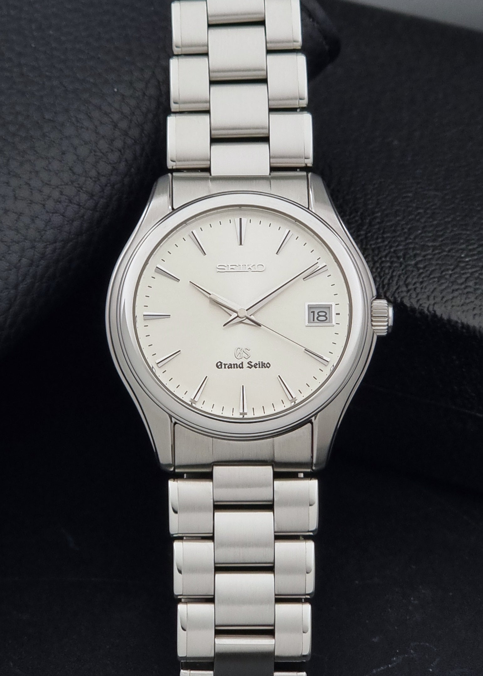 A Grand Seiko SBGX005 quartz watch 9F62-0A10 Sunburst Dial  with bracelet on a dark back ground a front view