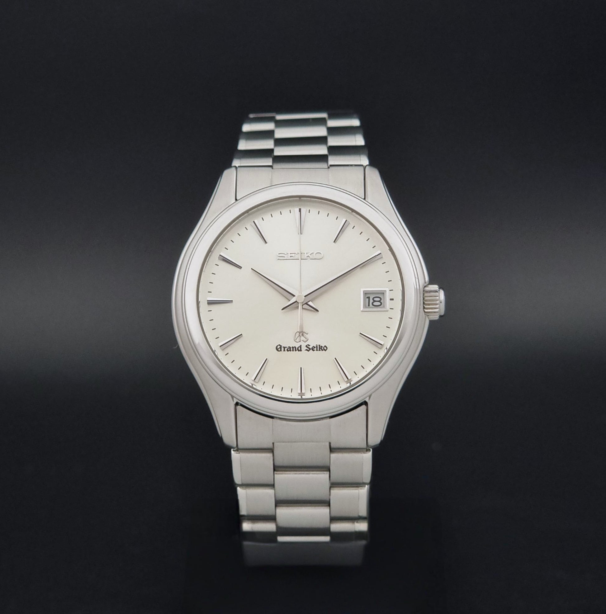 A Grand Seiko SBGX005 quartz watch 9F62-0A10 Sunburst Dial  with bracelet on a dark back ground shown against a dark black background.