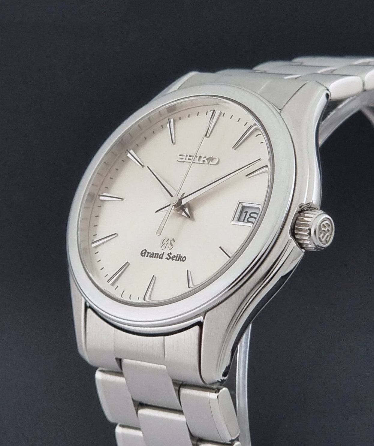 A Grand Seiko SBGX005 quartz watch 9F62-0A10 Sunburst Dial  with bracelet on a dark back ground a crown side view