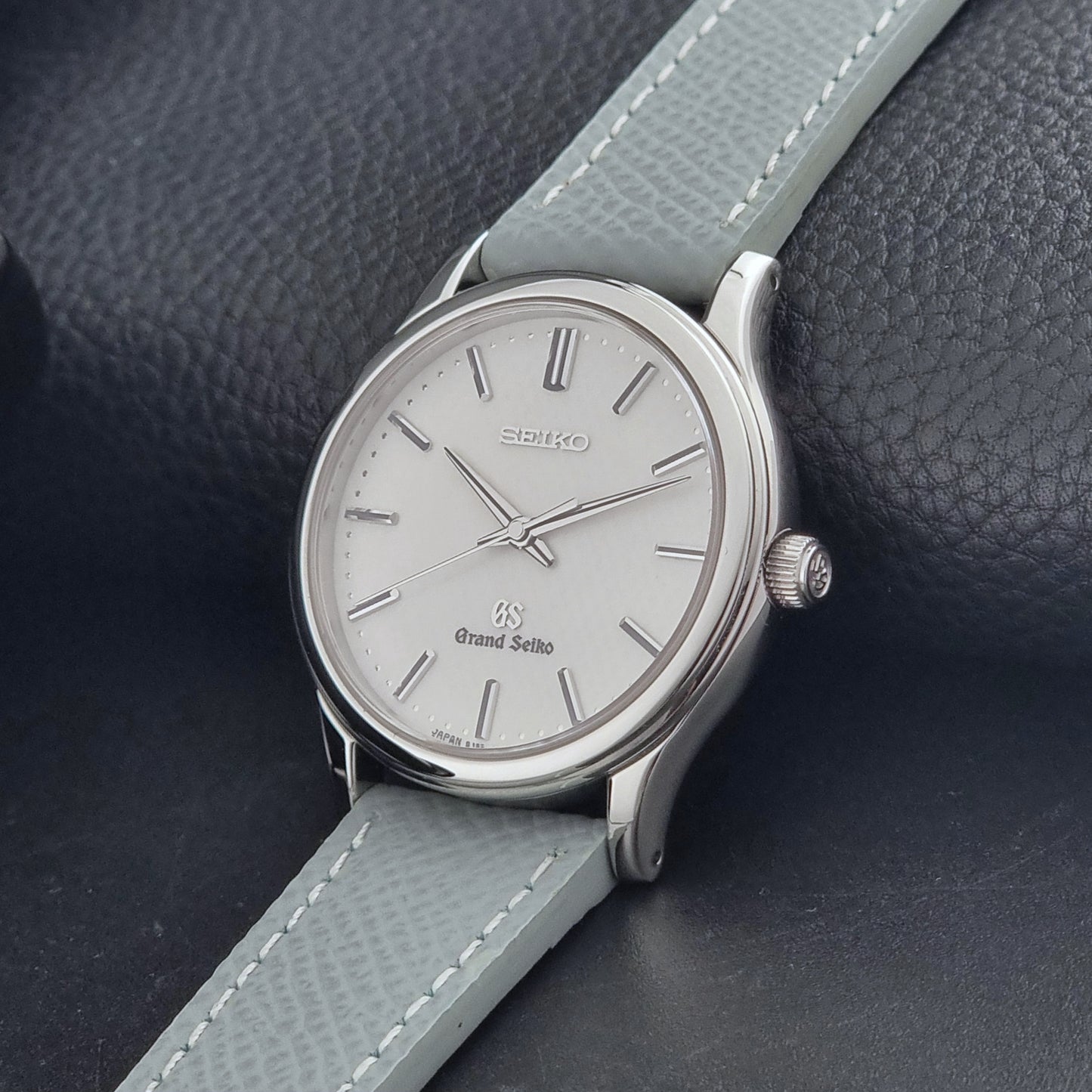 Grand Seiko SBGF029 quartz watch 8J55-0AA0  with light grey strap and silver case on a dark grey background crown view