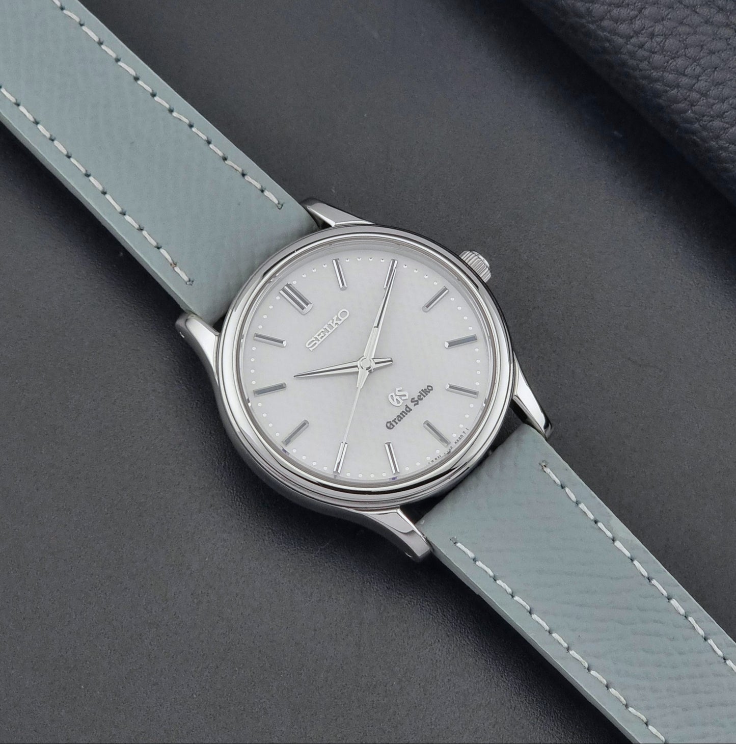 Grand Seiko SBGF029 quartz watch 8J55-0AA0  with light grey strap and silver case on a dark grey background dial