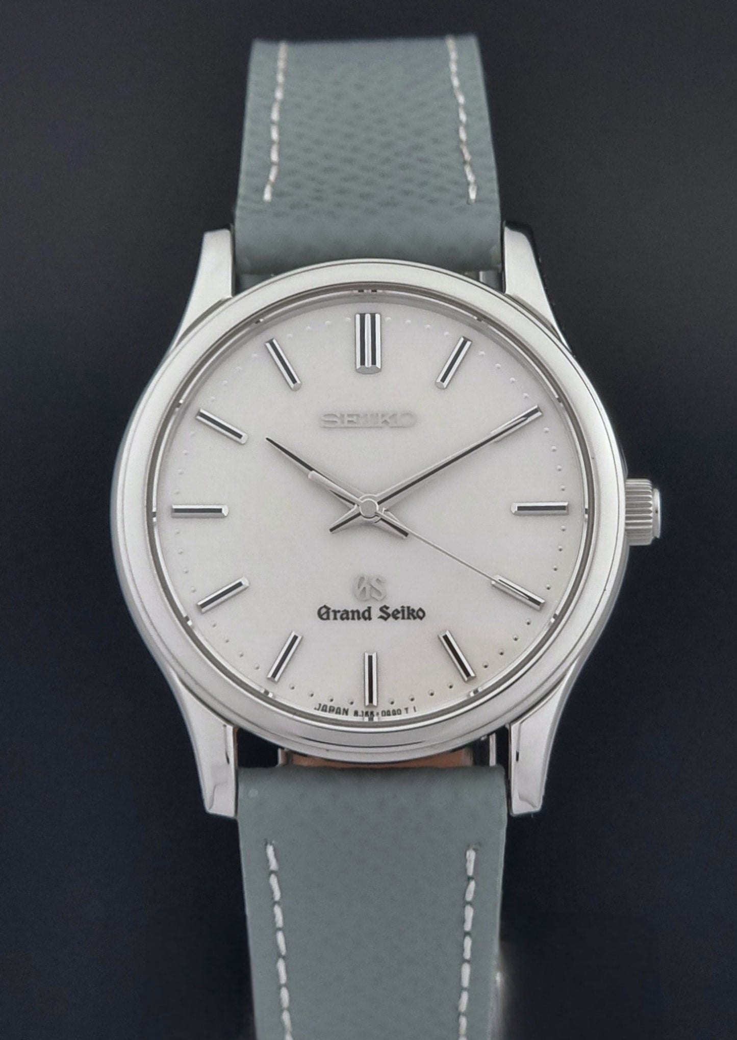 Grand Seiko SBGF029 quartz watch 8J55-0AA0  with light grey strap and silver case on a dark grey background close dial view