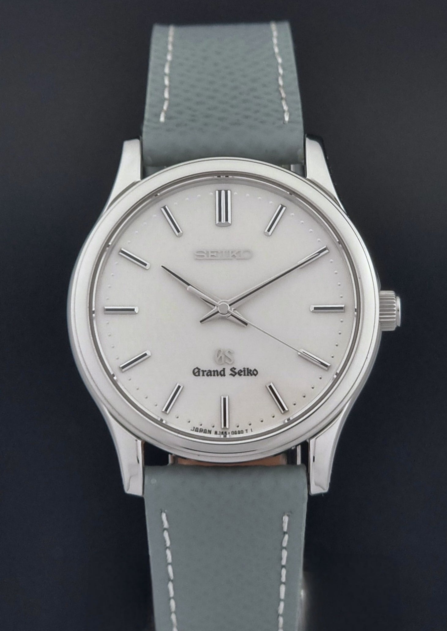 Grand Seiko SBGF029 quartz watch 8J55-0AA0  with light grey strap and silver case on a dark grey background close dial view