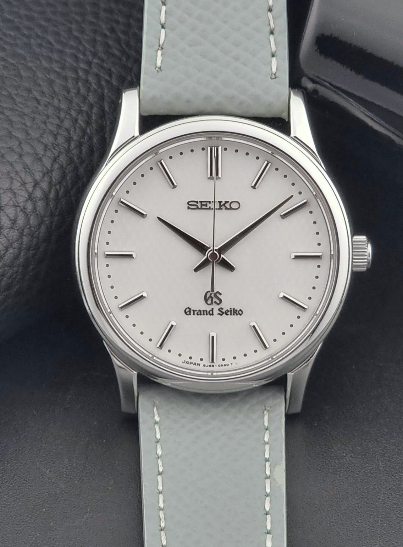 Grand Seiko SBGF029 quartz watch 8J55-0AA0  with light grey strap and silver case on a dark grey background dial view