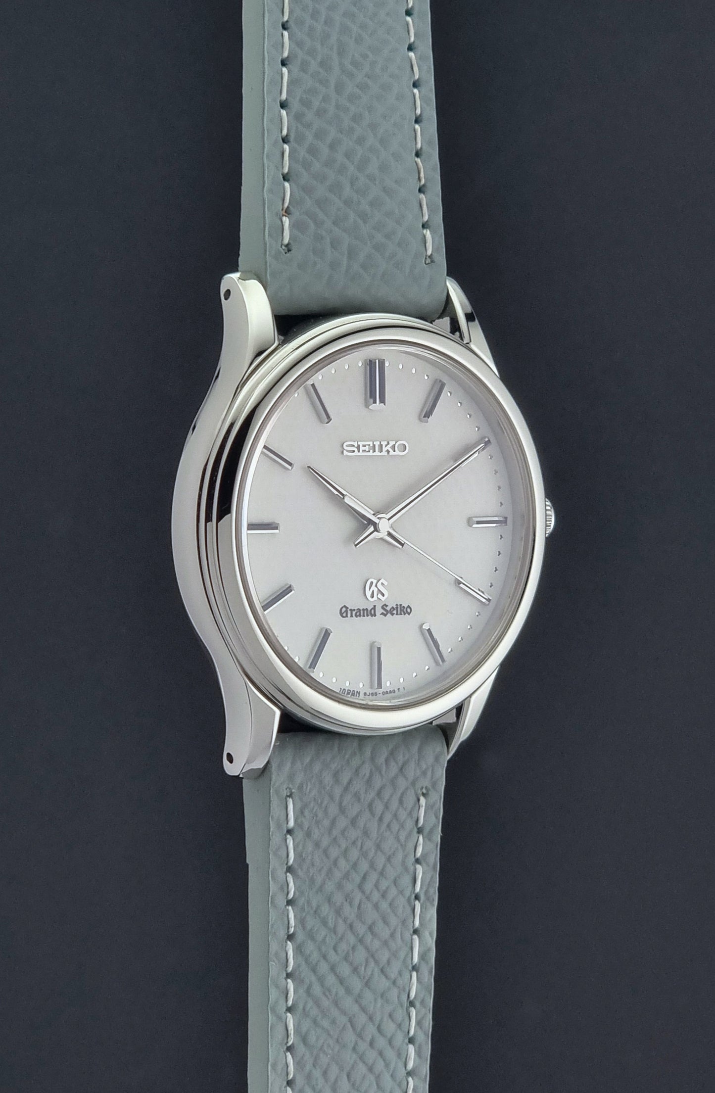 Grand Seiko SBGF029 quartz watch 8J55-0AA0  with light grey strap and silver case on a dark grey background side profile view