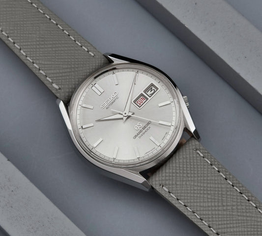 Vintage Grand Seiko watch with a textured strap on a gray background