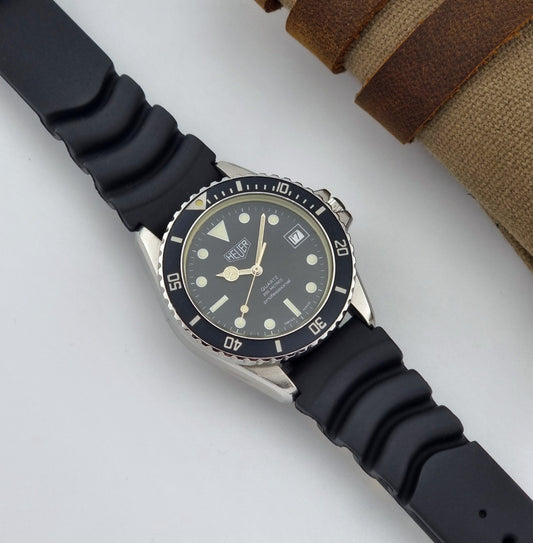 Vintage Heuer watch Quartz 200 meters Professional 980.013 Diver black strap and dark face on a white background front