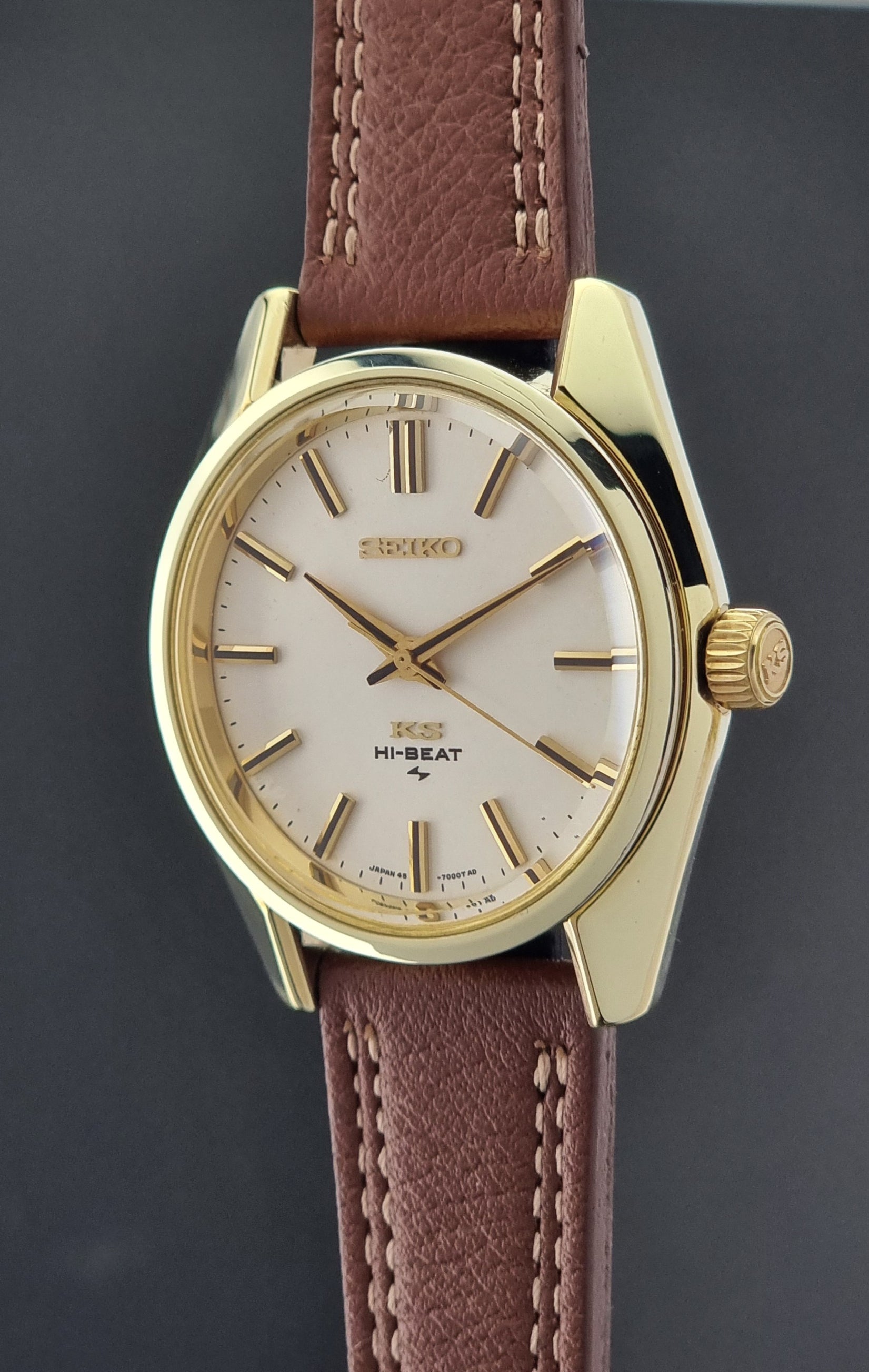 Gold Vintage King Seiko watch with a brown leather strap on a dark background