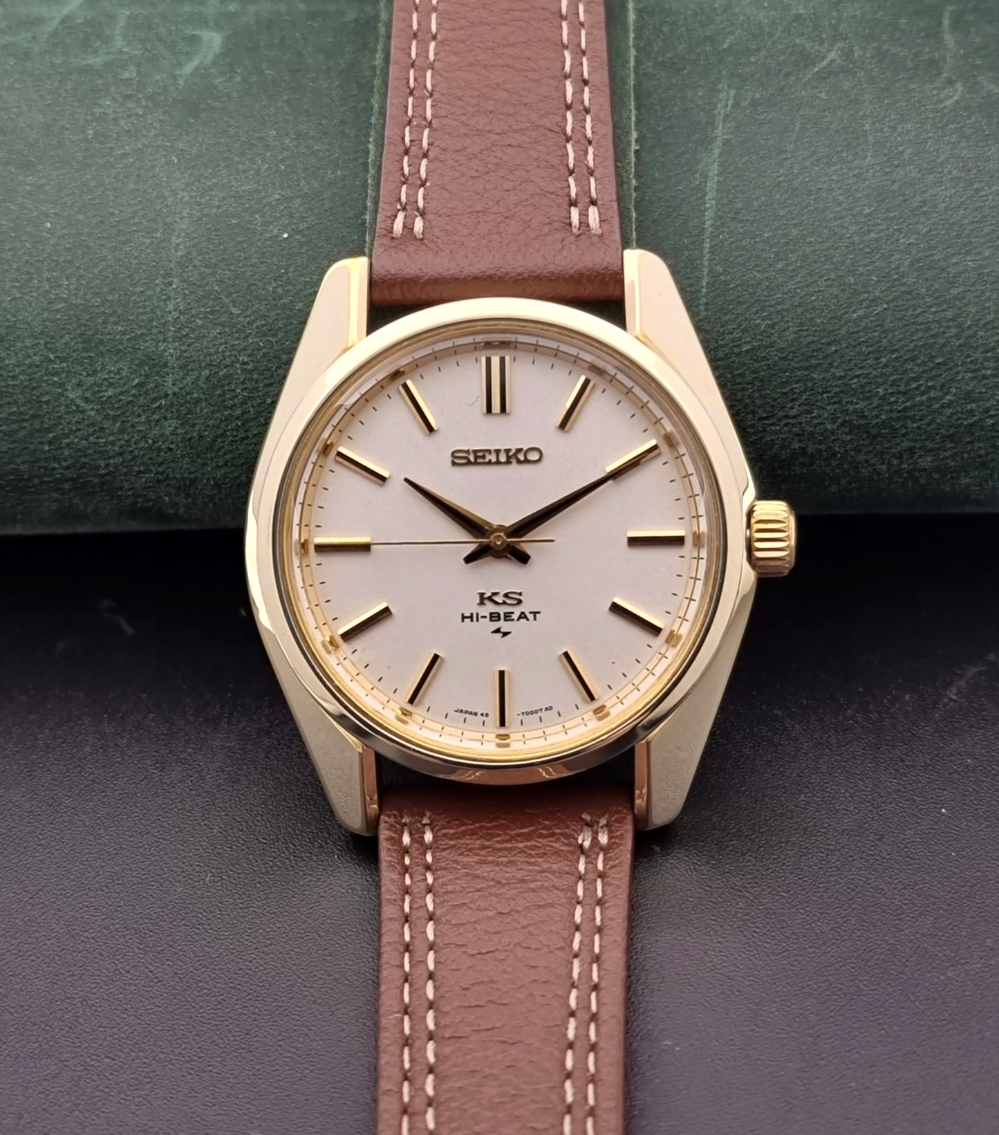 Vintage King Seiko watch with brown leather strap on a textured surface