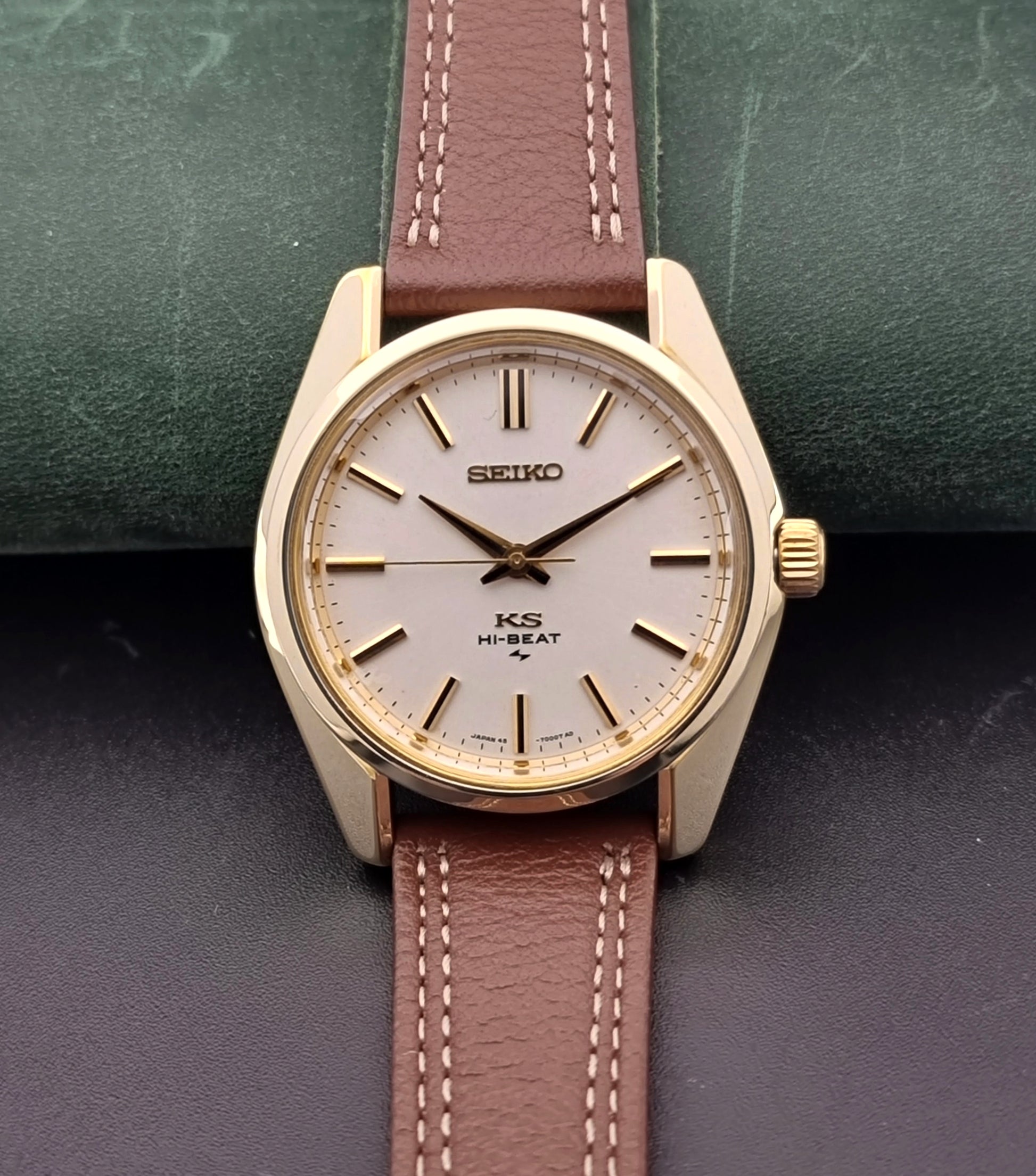 Vintage King Seiko watch with brown leather strap on a textured surface