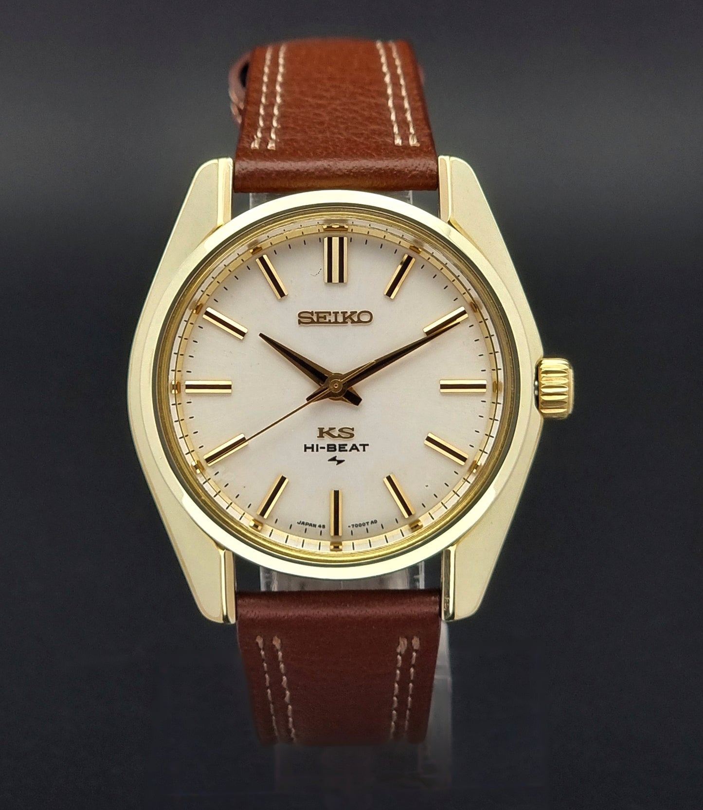 Vintage King Seiko watch with gold case and brown leather strap on a dark background